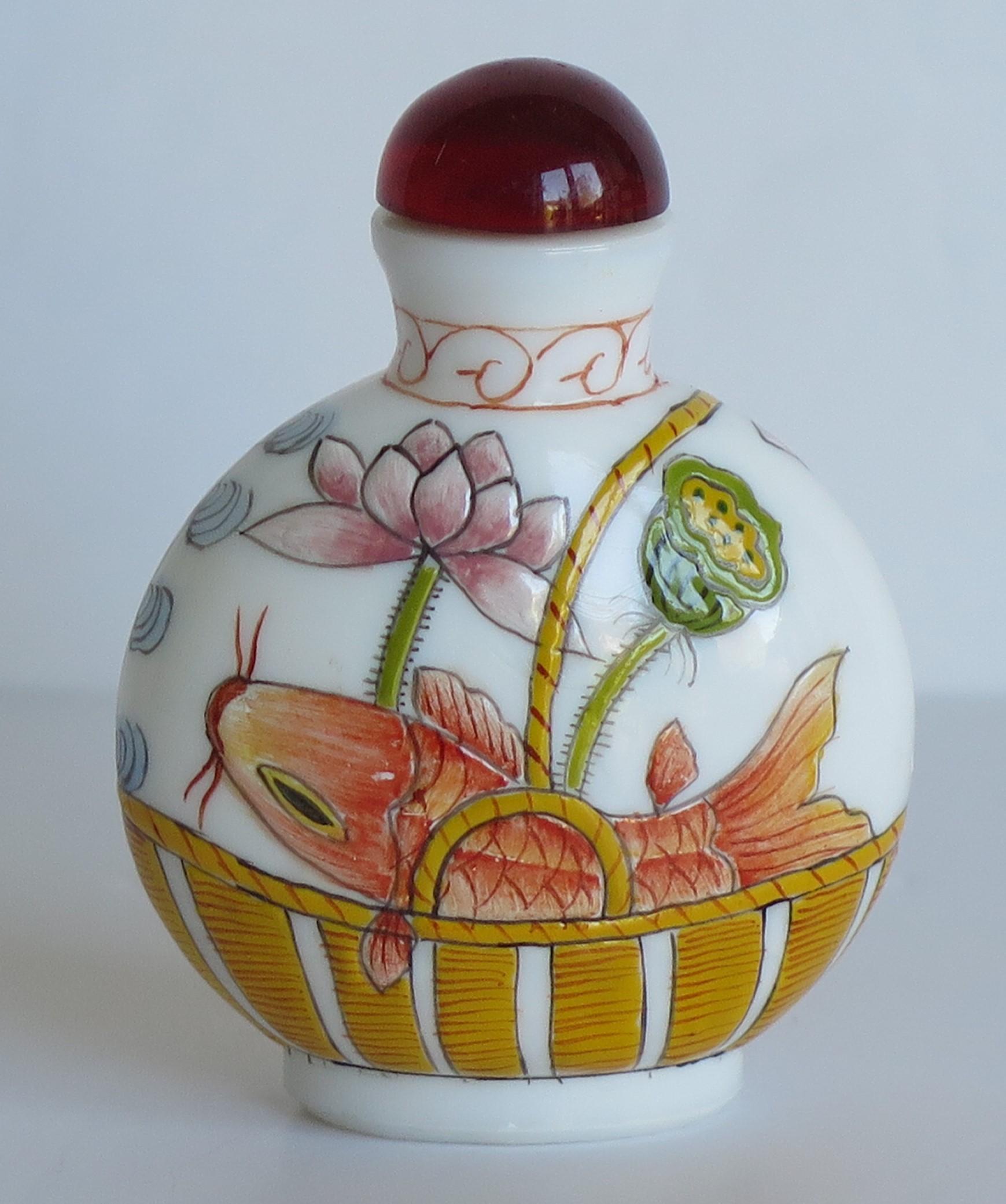This is a very good Chinese glass snuff bottle, beautifully hand enameled, which we date to the mid part of the 20th century, circa 1940.

It is made of a milky white opaque glass and sits on a low oval foot. The bottle has been delicately hand