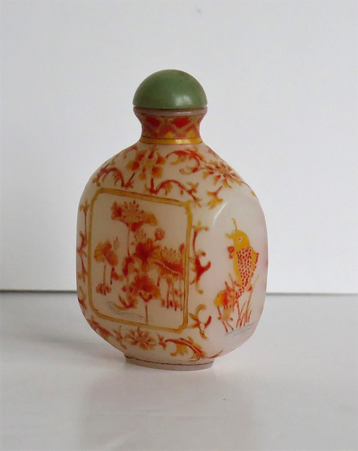 This is a very good Chinese glass snuff bottle, beautifully hand enameled, which we date to the earlier part of the 20th century, circa 1920 or possibly earlier

It is made of a milky white opaque glass and sits on a low oval foot. The bottle has