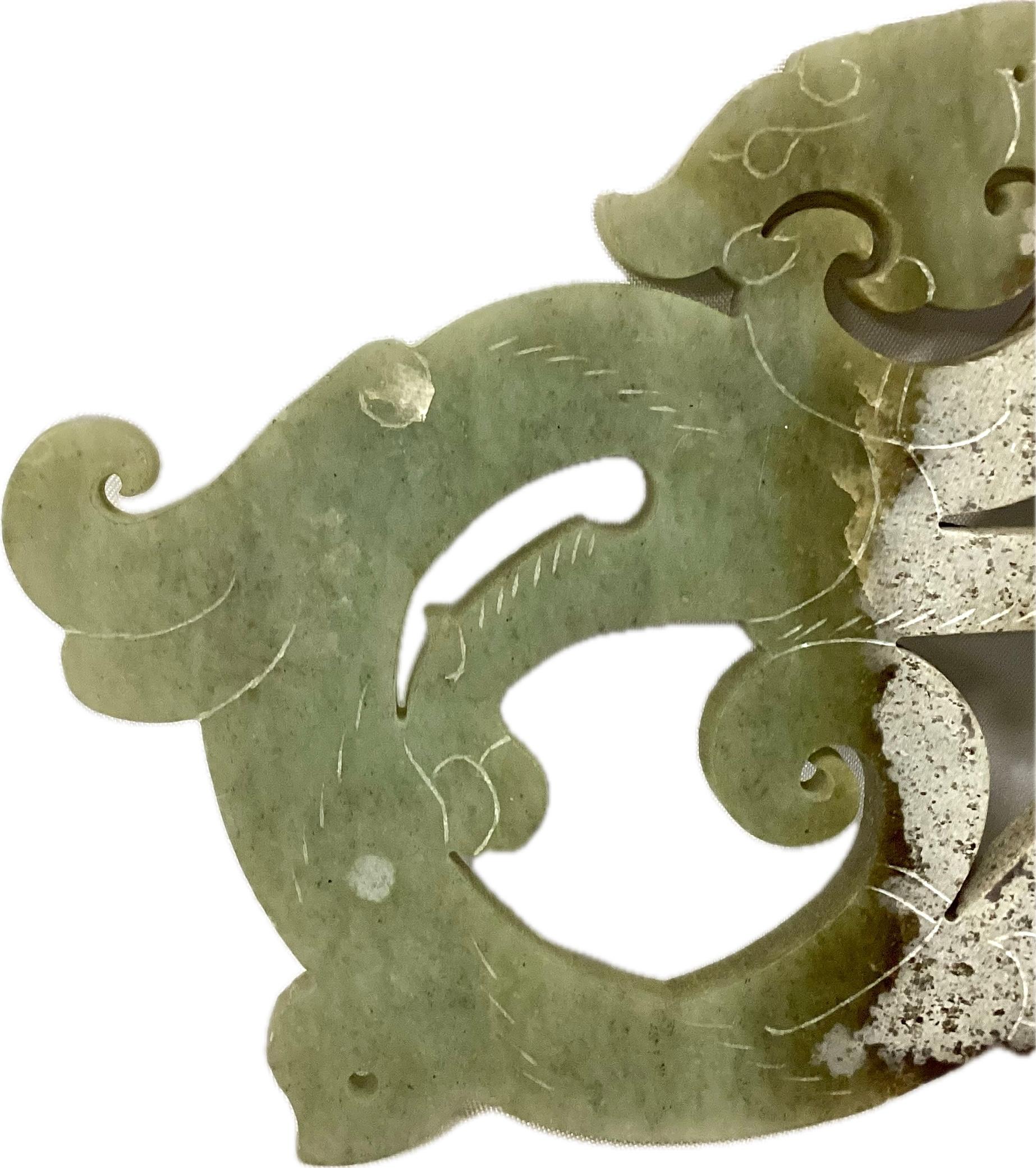 Chinese Open Work Carved white and green jade dragon and phoenix plaque. Plaque features coiling entwined dragon and phoenix, each with curling scrollwork from tails and bodies with delicate incised markings.   Has three small holes for hanging. 