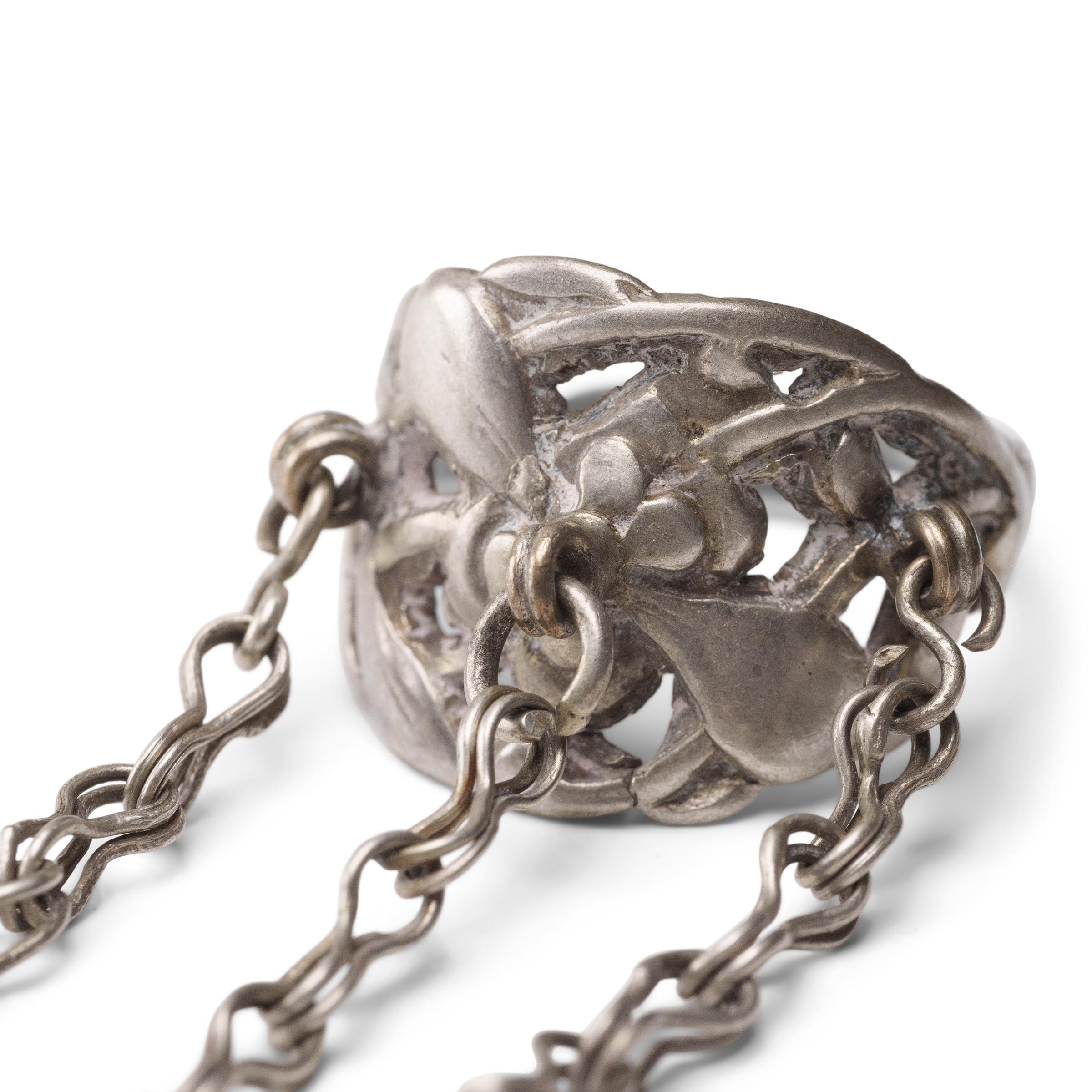 Dated to the late 19th century, this silver charm ring was crafted by the Miao peoples of Guizhou province and was believed to protect the wearer from bad luck and malevolent spirits. The ring band has a pierced, low relief design of an elegant