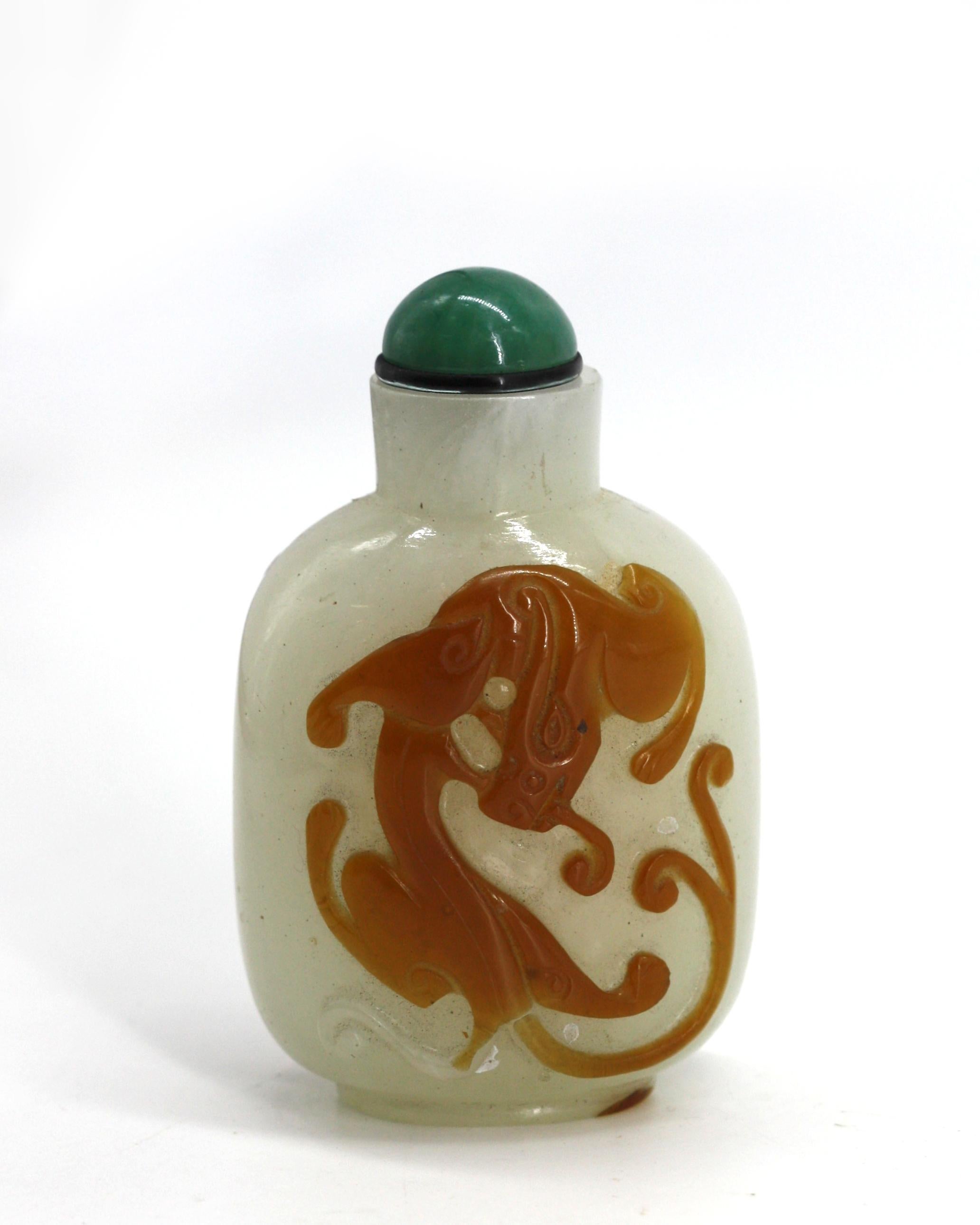 
Bouteille à priser de Masterly en verre de Pékin superposé chinois
Le corps sphérique en céladon pâle est recouvert de chaque côté d'une chimère de couleur ambre, sur un pied surélevé, un capuchon en jade avec une boule, (boule endommagée).
Rapport