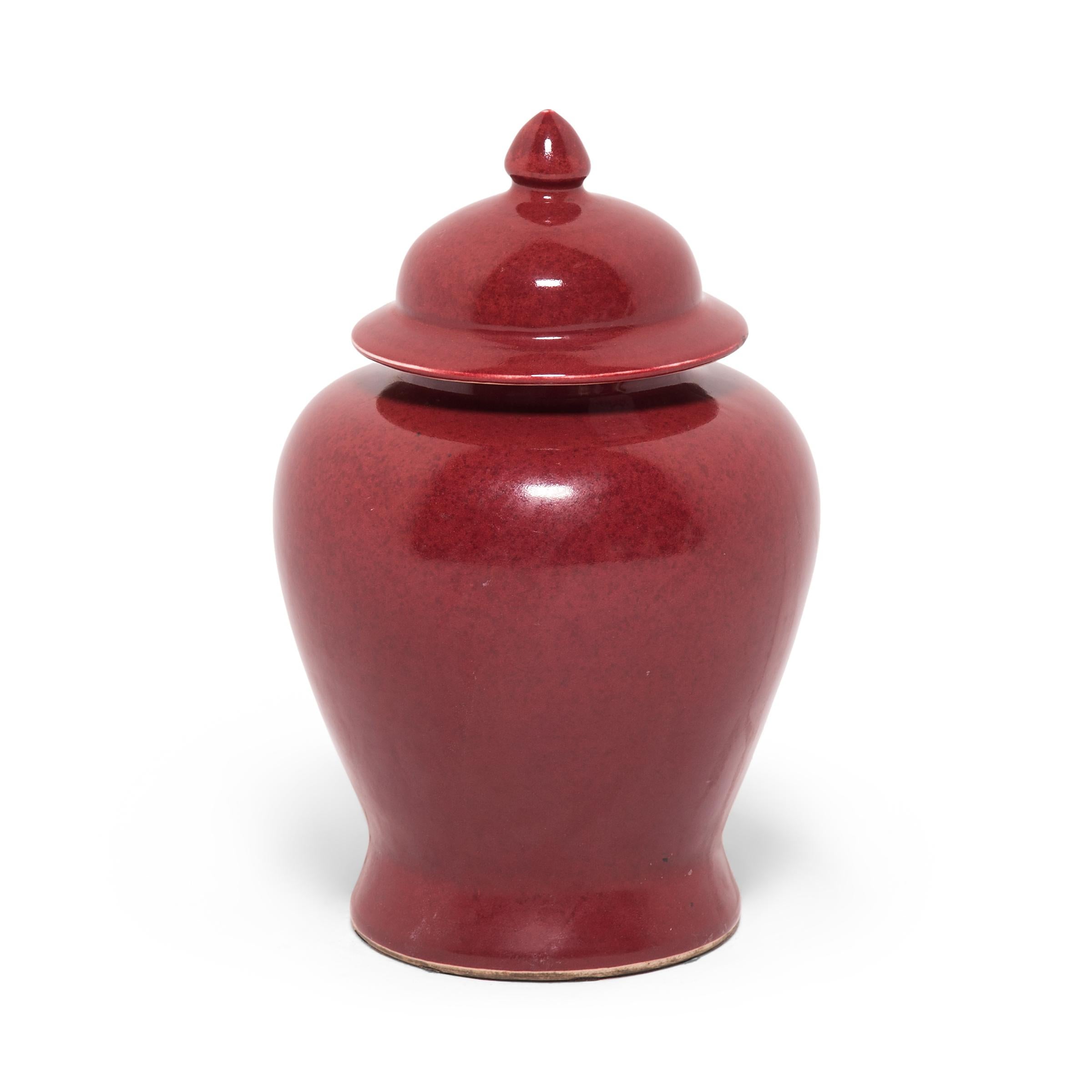 This contemporary take on the traditional ginger form emphasizes its rich color and elegant shape - characterized by its rounded body, high shoulders, and domed lid. The vase's deep, rich red glaze is often called 