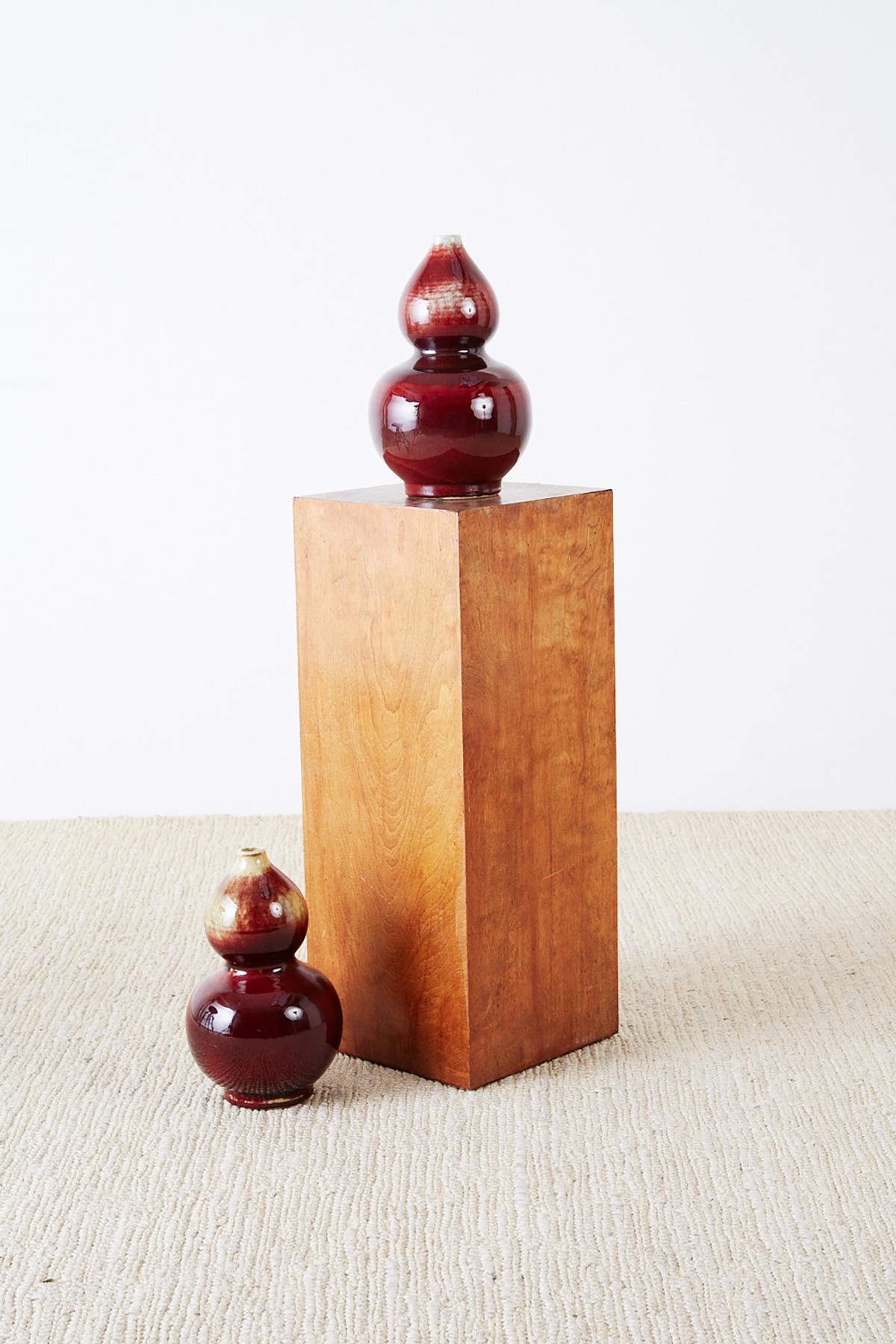 Outstanding pair of Chinese late 19th century Lang Yao vases having a double gourd form. Featuring a rich oxblood sang de boeuf glaze with a fine craquelure in the finish. Each vase is very heavy weighing 7 lbs with a beautiful under glaze showing