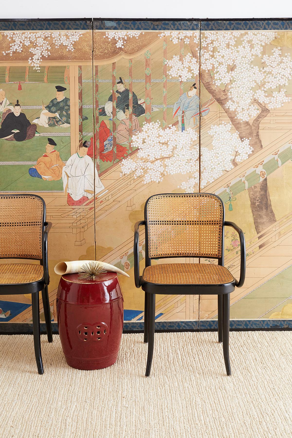 Rare pair of Chinese garden seats or drink tables finished in an oxblood red enamel made in the Sang de Boeuf style. Decorated with lucky Chinese coin motifs in the center and handles on the sides. Each has a rich glaze with interesting beige color