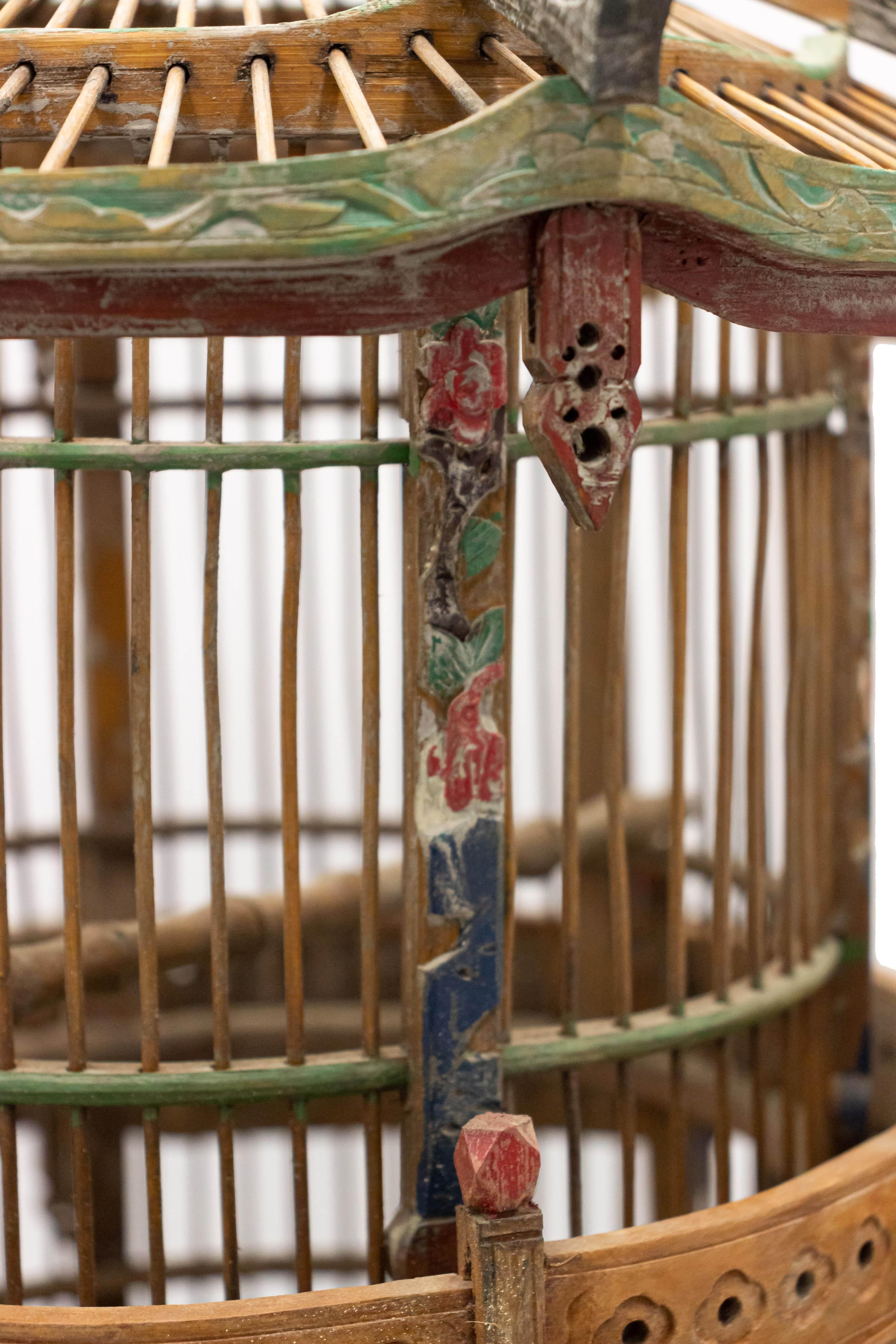 Asian Chinese style bamboo bird cage in the shape of a pagoda with painted detail.