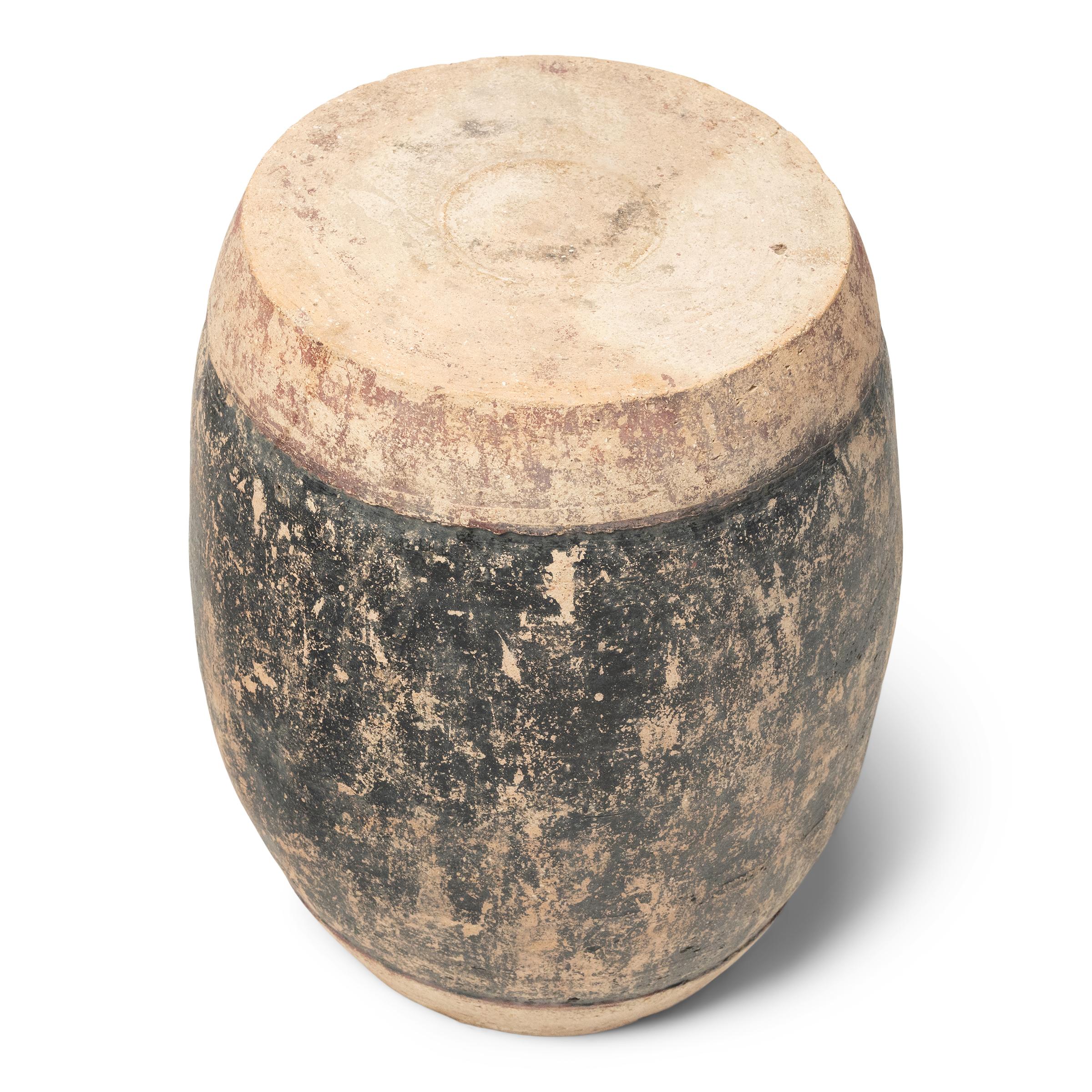 This early 20th-century ceramic garden stool is the ultimate in rough luxe. The earthenware stool is sculpted to a traditional drum shape, with gracefully curved sides and a contrasting top and bottom, a nod to the stretched hide surfaces of an
