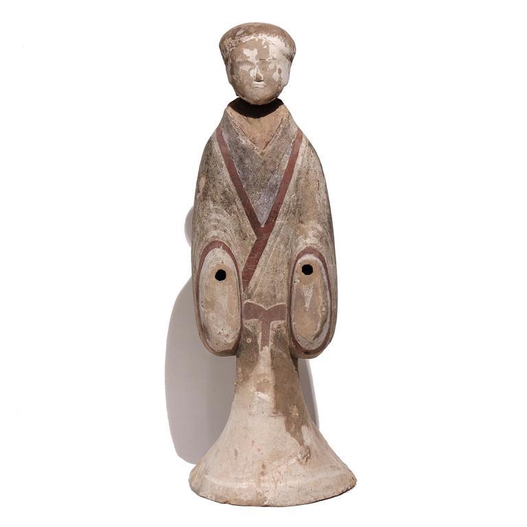 Chinese painted grey earthenware standing female figure, Western Han dynasty. 
The tall slender court lady stands with knees and elbows slightly bent to reveal the hands, now lost with sockets remaining. The detachable rounded head has a delicately