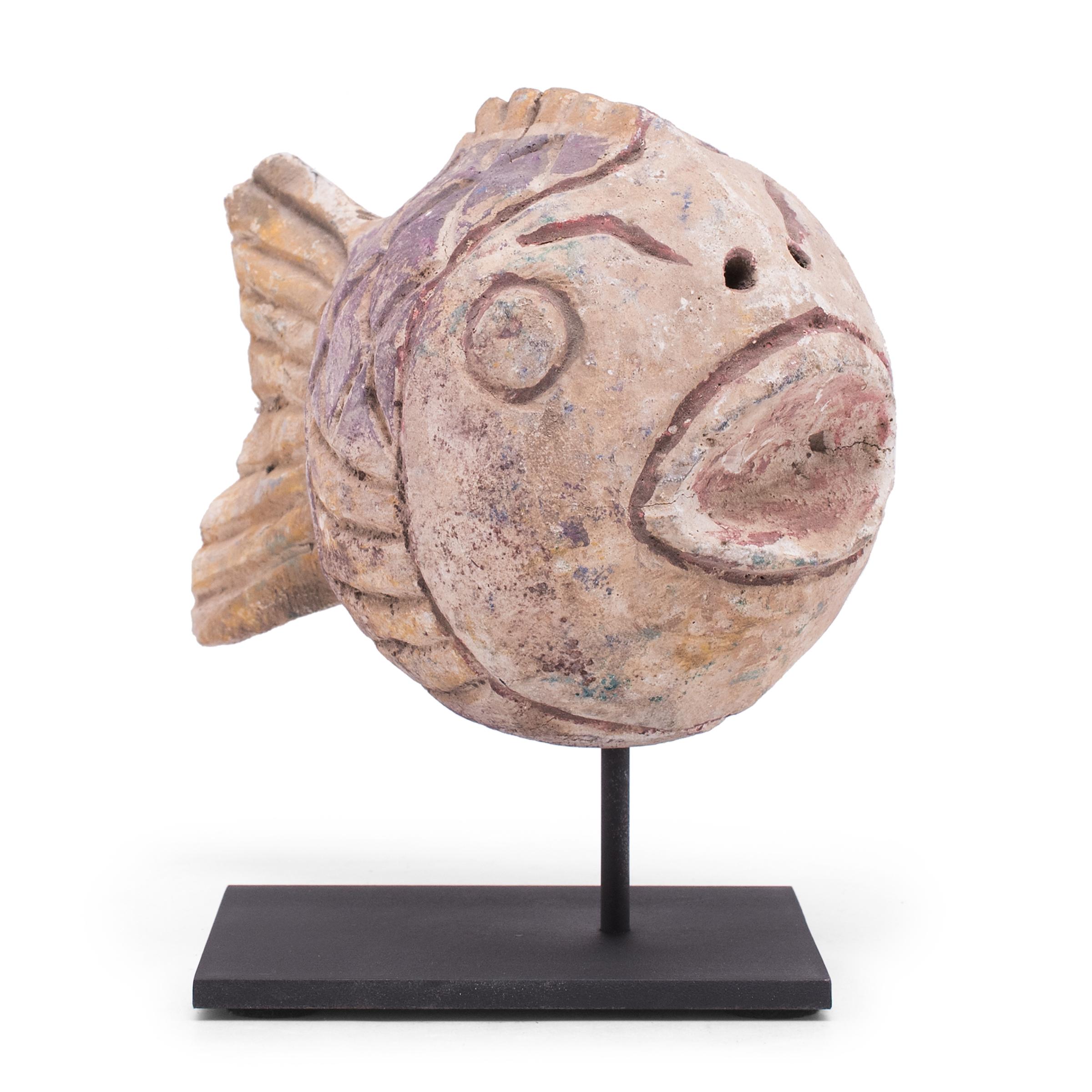 Hand-carved from reclaimed wood, this rustic fish sculpture recreates early 20th-century Chinese folk art designs. The fish is painted with a colorful palette of purple, red and yellow and finished with a beautifully worn texture. Common motifs in