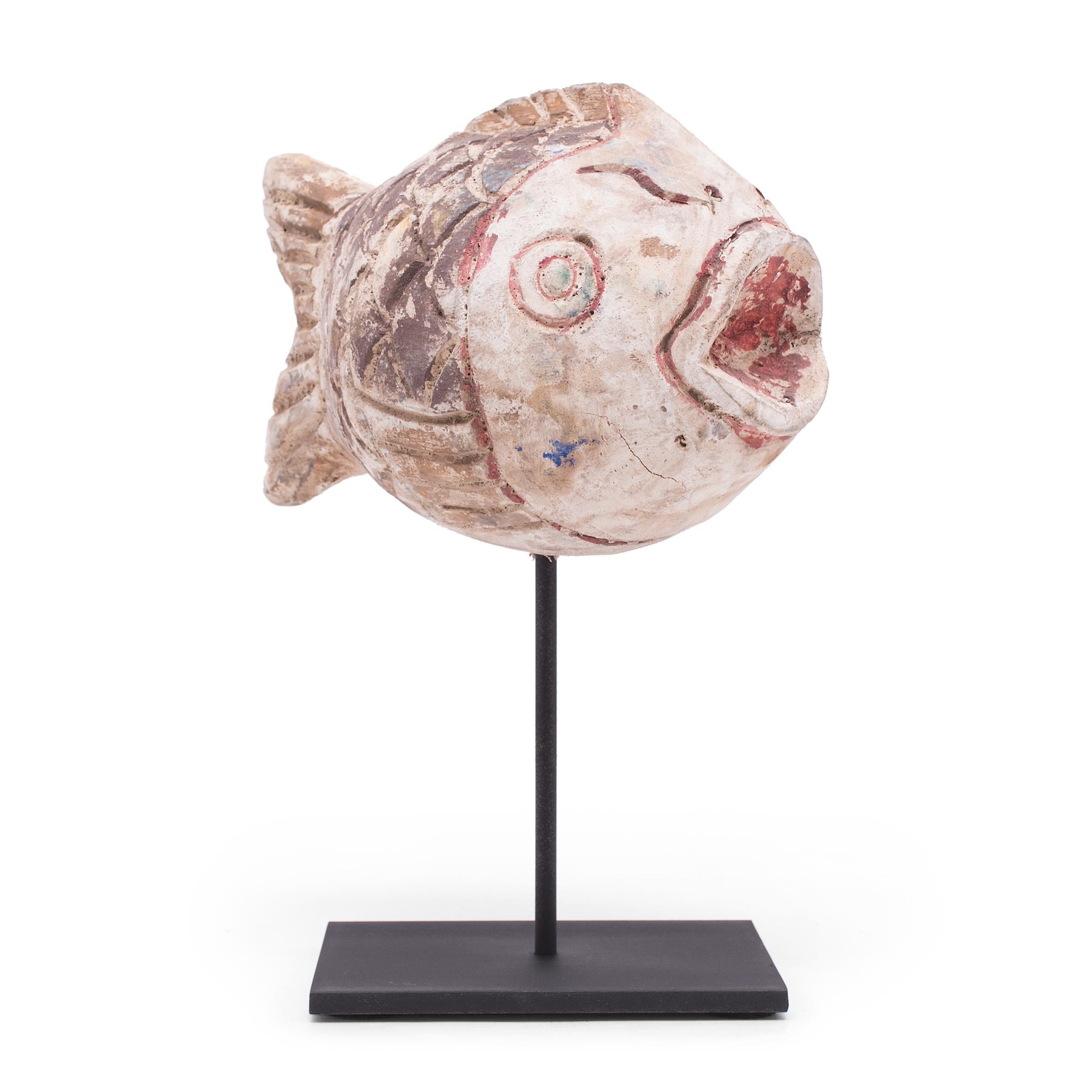 Hand-carved from reclaimed wood, this rustic fish sculpture recreates early 20th-century Chinese Folk Art designs. The fish is painted with a colorful palette of brown, purple, red and yellow and finished with a beautifully worn texture. Common