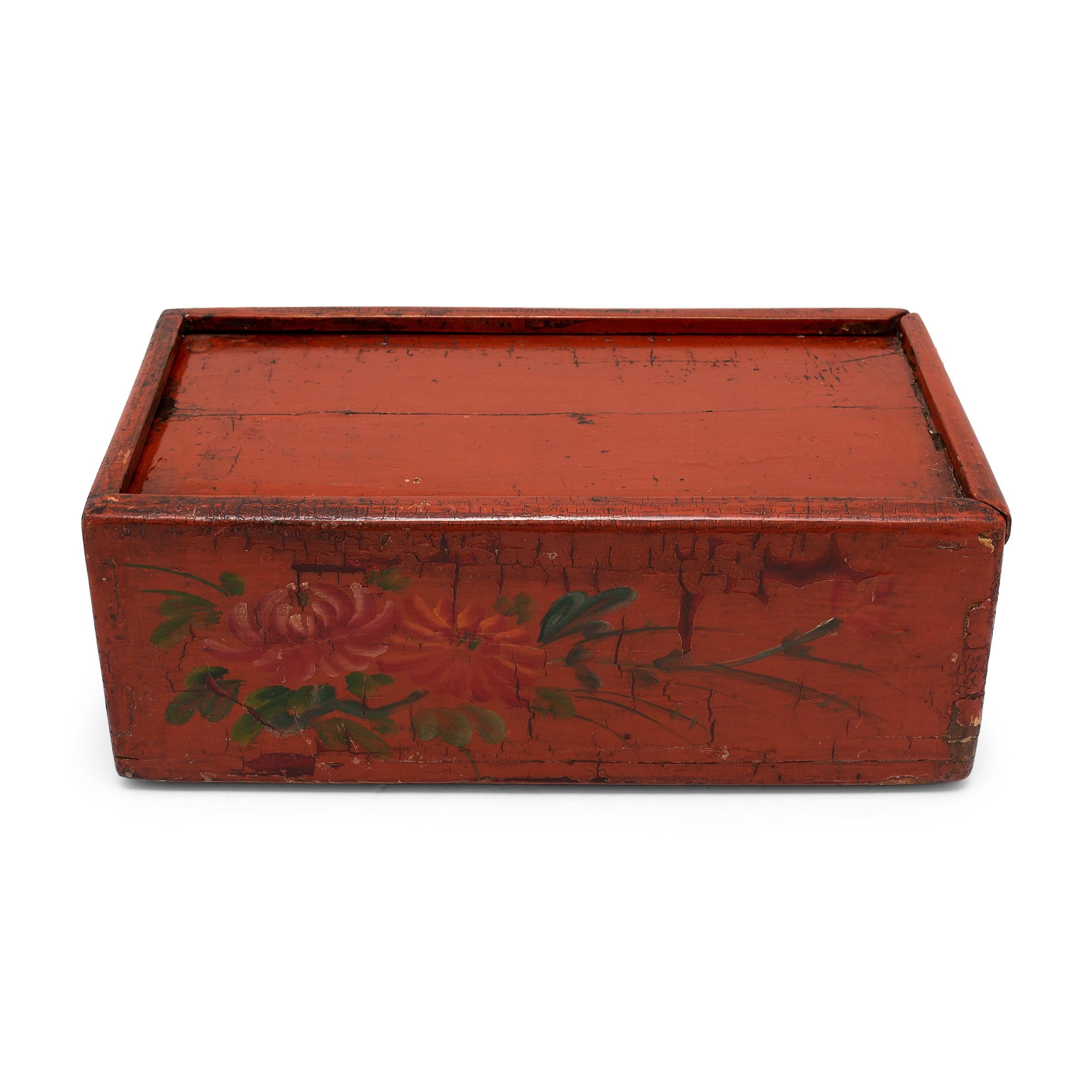 This painted wooden box dates to the mid-19th century and was likely used as a document chest in a Qing-dynasty office or scholars' studio. Crafted with a sliding lid, the box was used to store and protect painted scrolls and official documents. The