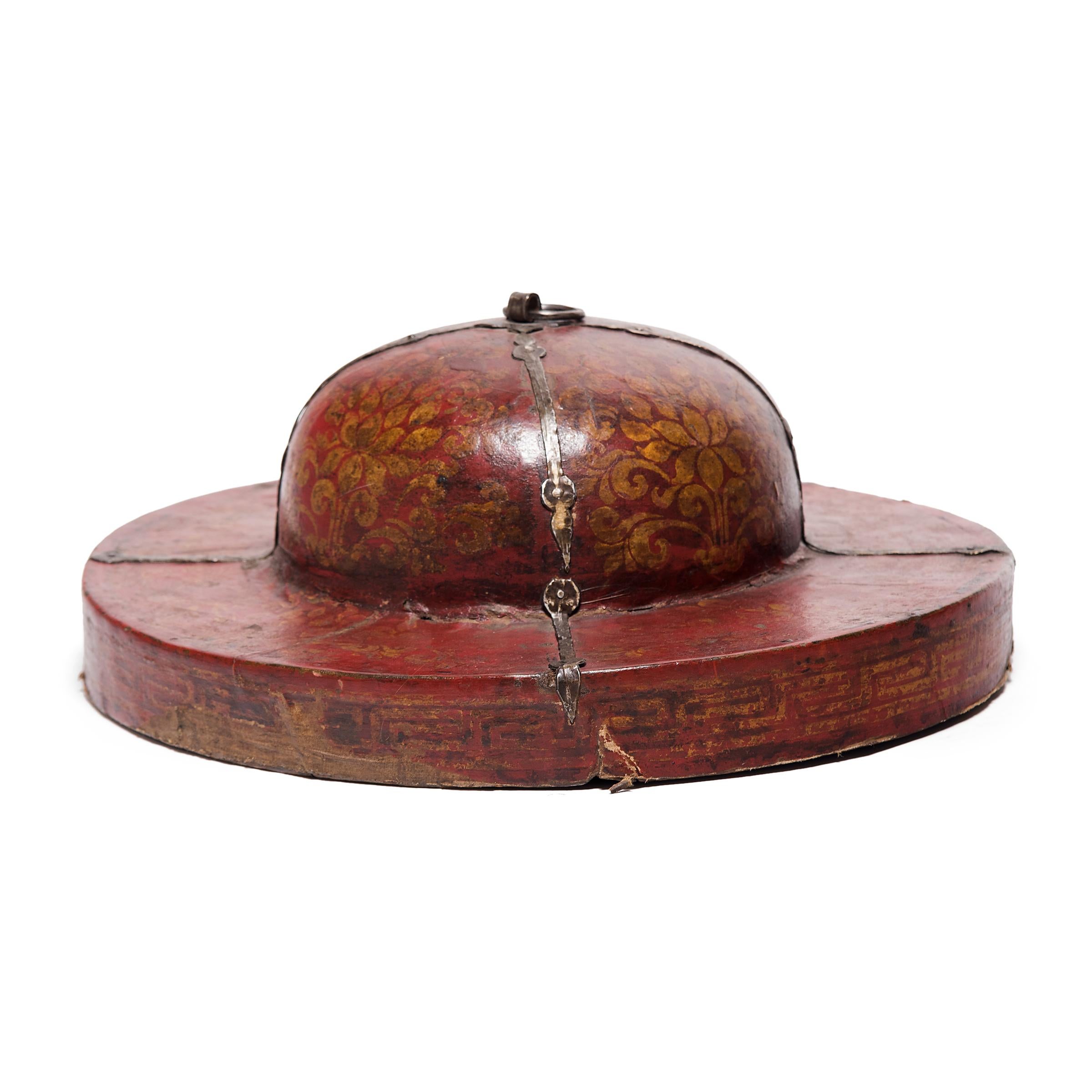 Orné de motifs et encadré de ferrures en laiton, ce couvercle de boîte datant du XIXe siècle contenait à l'origine une paire de grandes cymbales tibétaines. Utilisées lors des processions et des spectacles de danse, les cymbales servaient de support