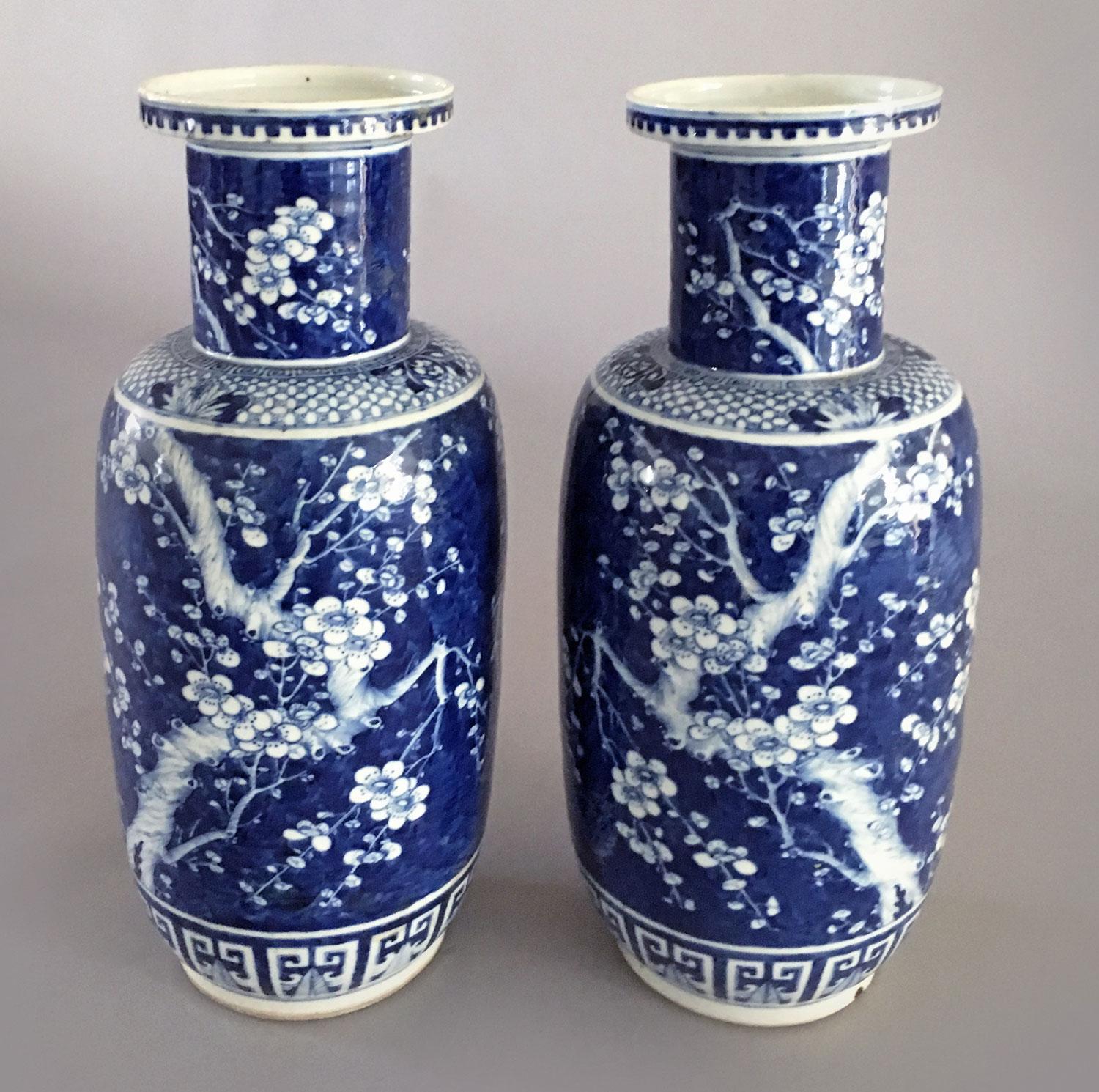 Pair of Chinese porcelain blue and white Rouleau shaped vases with straight cylindrical sides and a straight narrow neck, decorated with the prunus pattern of blossoms and branches on a cracked ice background. The top rim has a dental design, the