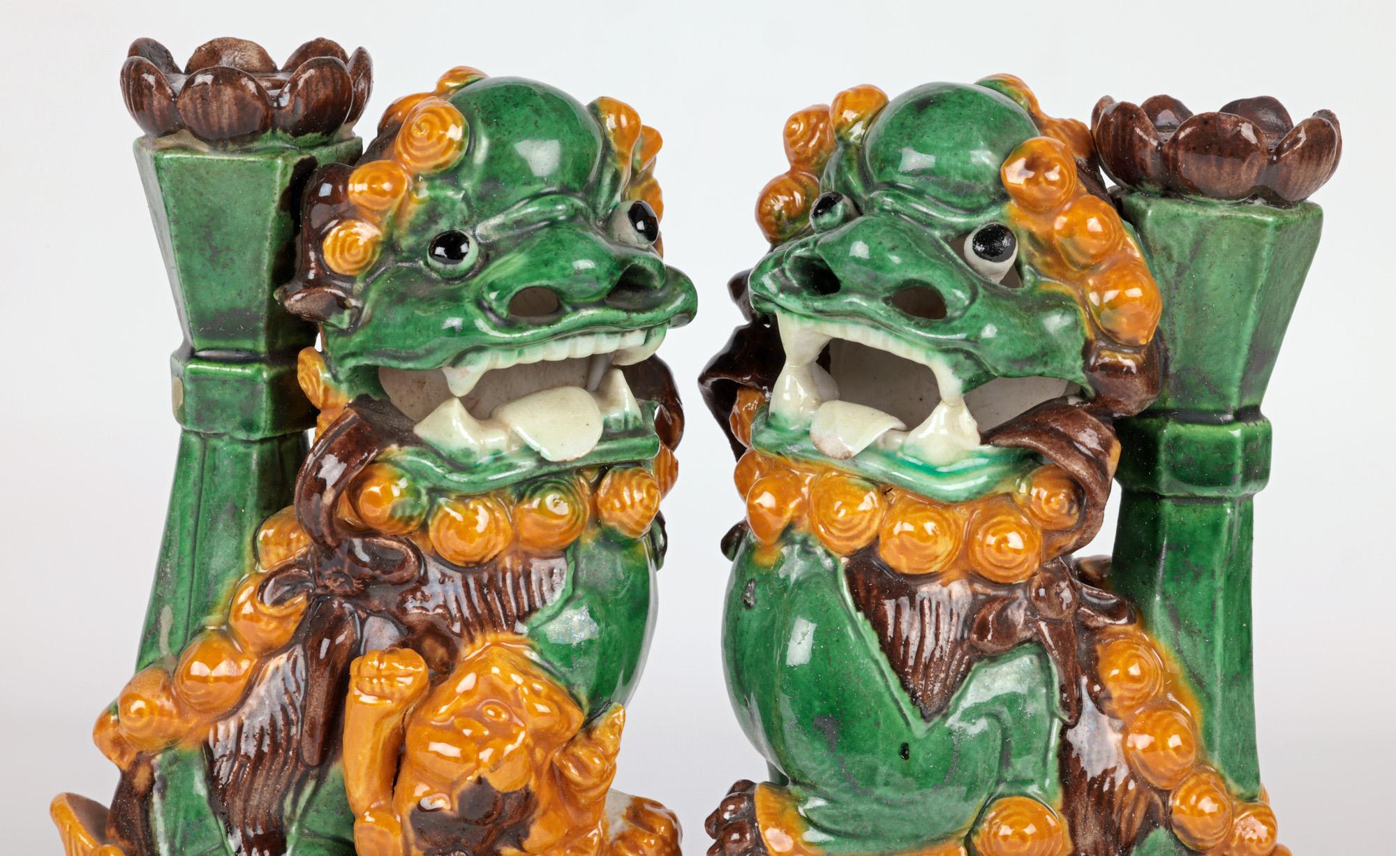 A very fine pair Chinese Qing sancai glazed pottery dog of Foo incense holder figures dating from the 18/19th century. The figures stand raised on hollow rectangular pierced pedestal altar shaped bases with a draped cloth to the front and back. The
