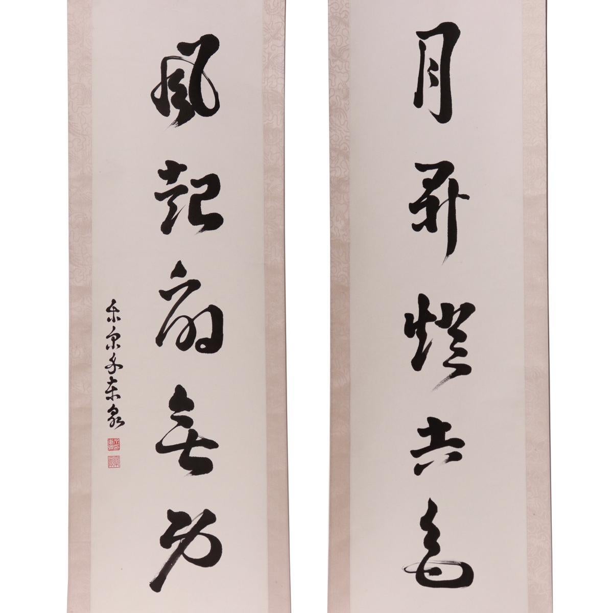 Chinese Pair of Calligraphy Scrolls, vertical lines of calligraphy executed in a light style, right reading: “Moon Rises and the Candle has no Effect” and the left reading: “Wind Rises and the Fan looses its Duty” Signed Luo Er Dong Zhuang (Lo Erh