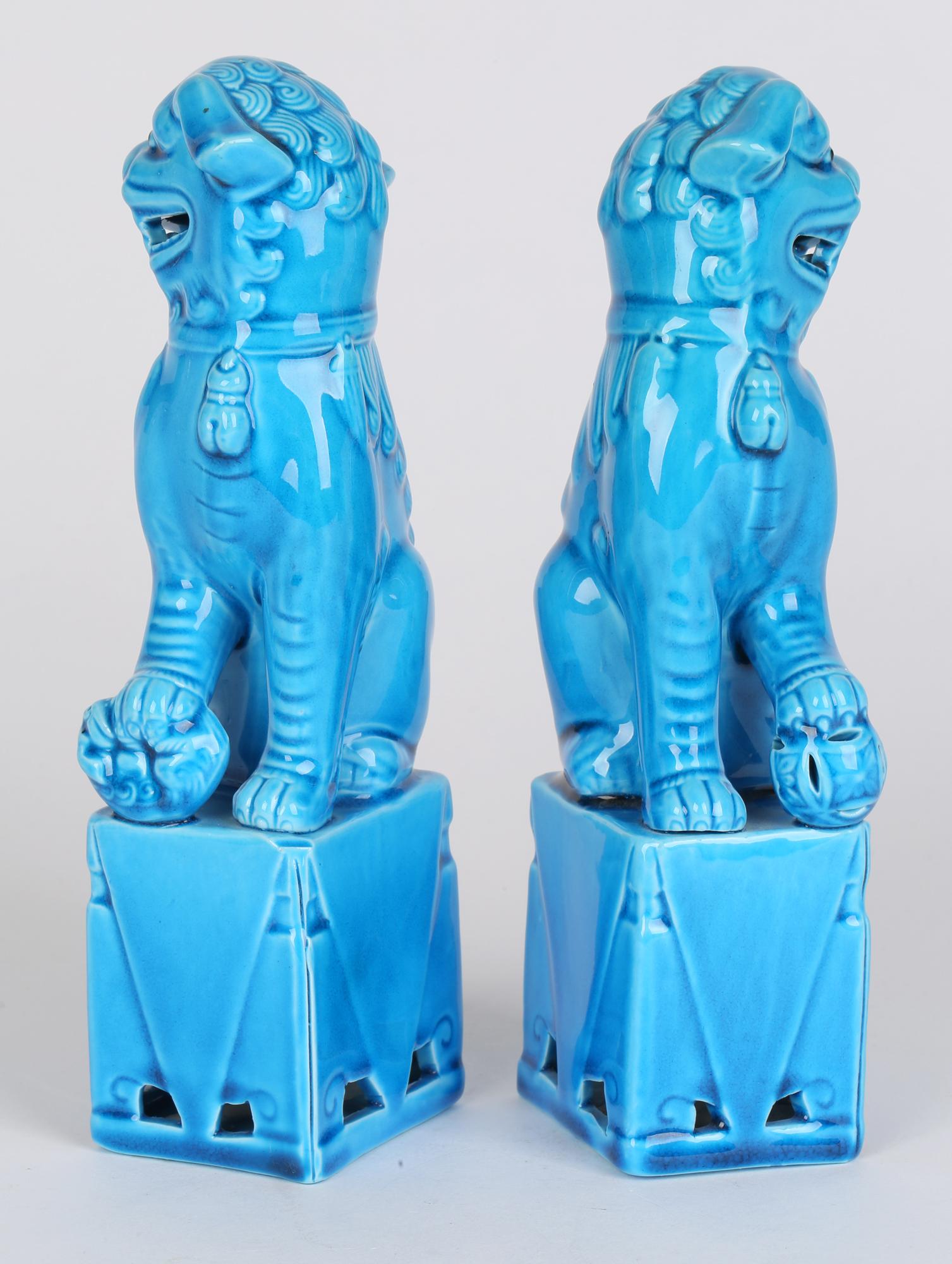 A very fine and attractive pair of Chinese turquoise glazed dogs of foo figures dating from the first half of the 20th century. The hollow biscuit porcelain figures stand raised on a rectangular base and are looking sideways with open mouths showing
