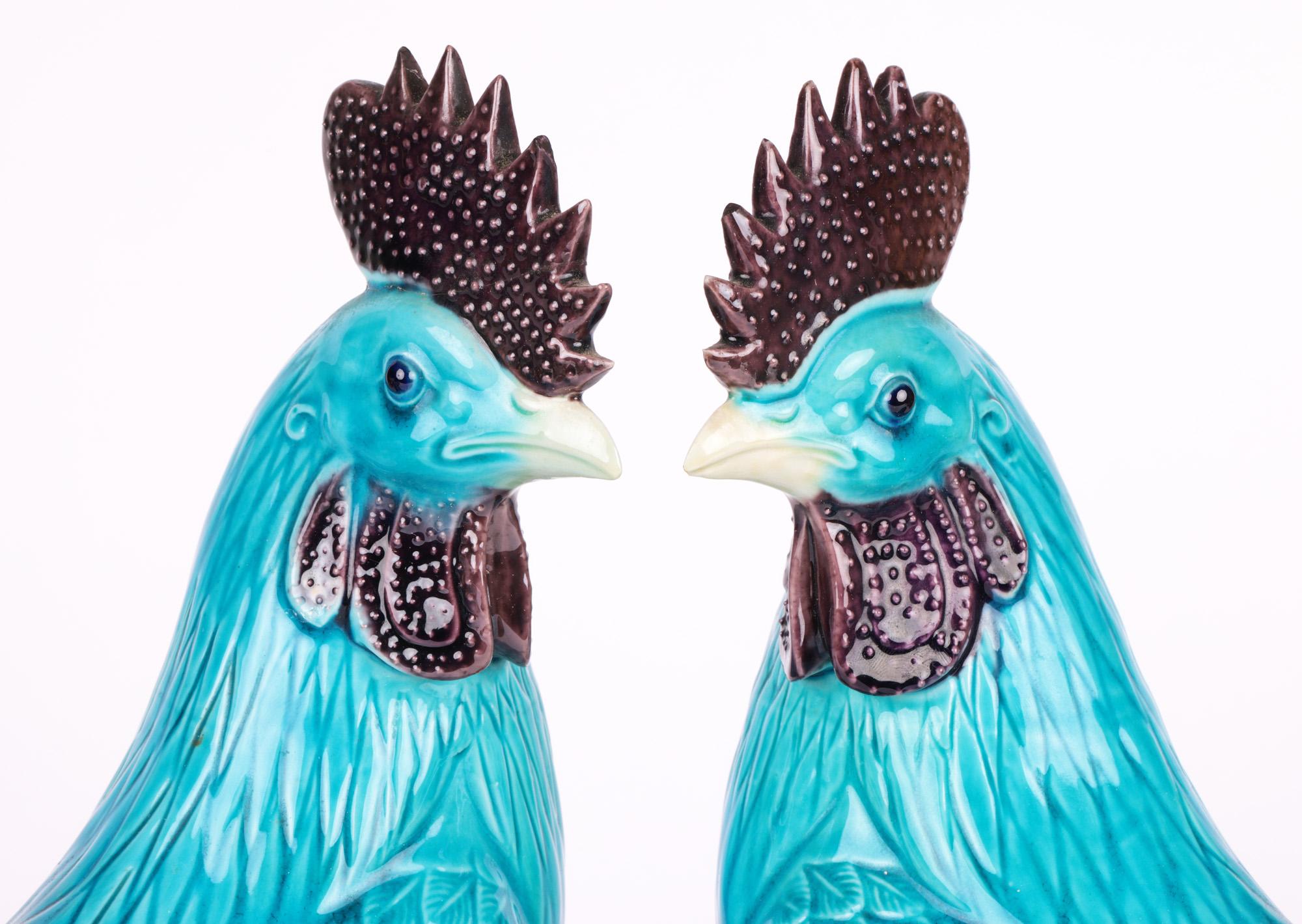 A very fine and attractive pair of Chinese turquoise glazed cockerel figures dating from the first half of the 20th century. The hollow biscuit porcelain figures stand perched on a rock work mound with their heads turned sideways. They are both well