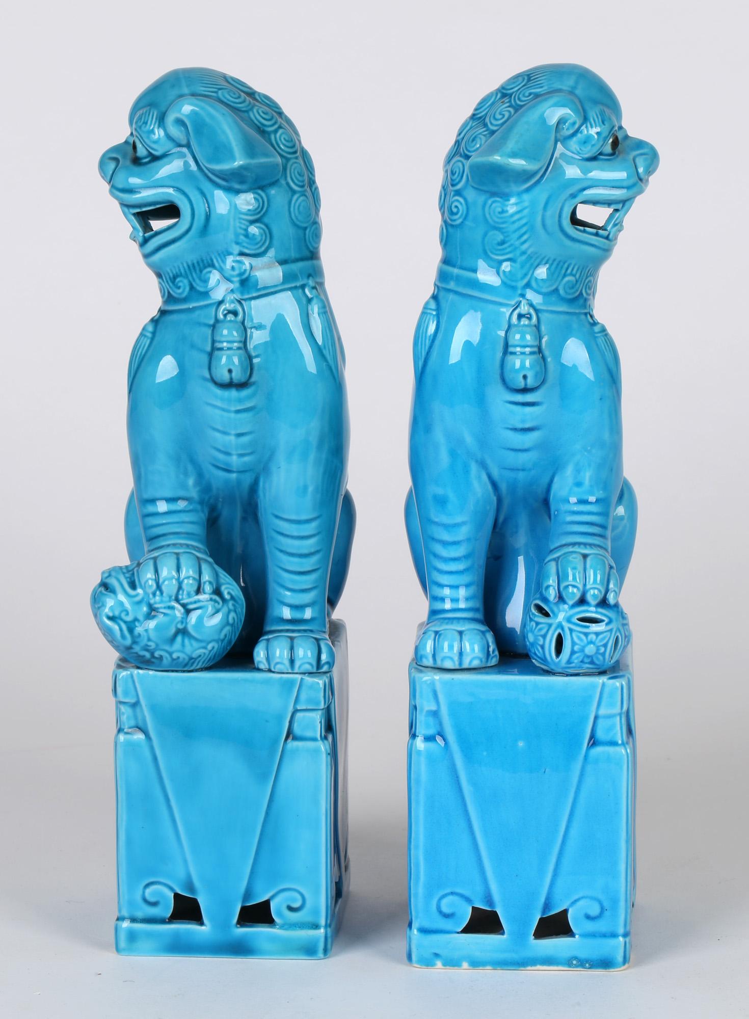A very fine and attractive pair Chinese turquoise glazed dogs of foo figures dating from the first half of the 20th century. The hollow biscuit porcelain figures stand raised on a rectangular base and are looking sideways with open mouths showing