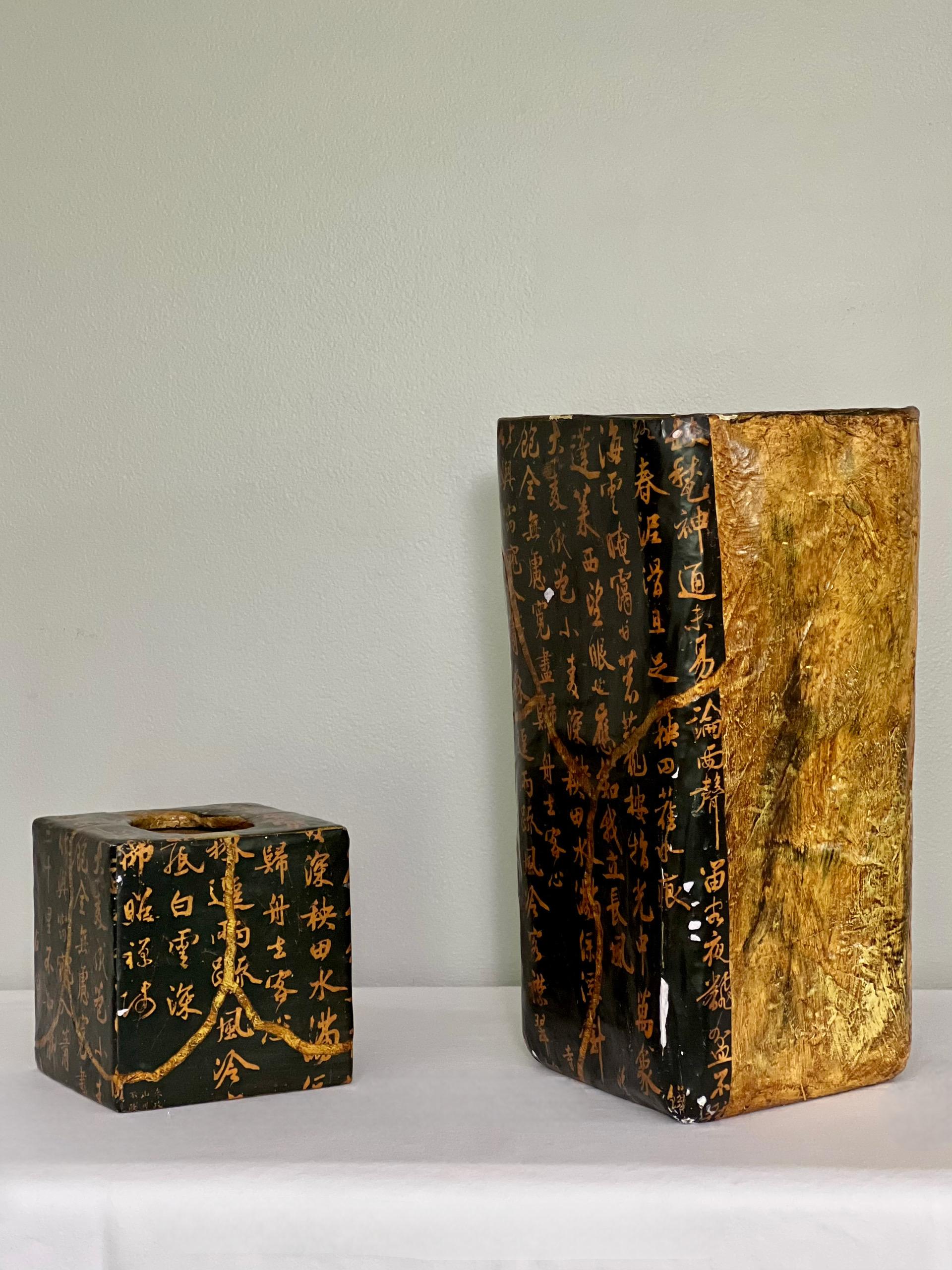 Vintage mid 20th century Chinese lacquered papier-mâché wastepaper basket and matching tissue box cover set.  The basket has an organic, skewed square form with rounded edges and a decorative two-tone design.  Both pieces feature gilt calligraphy on