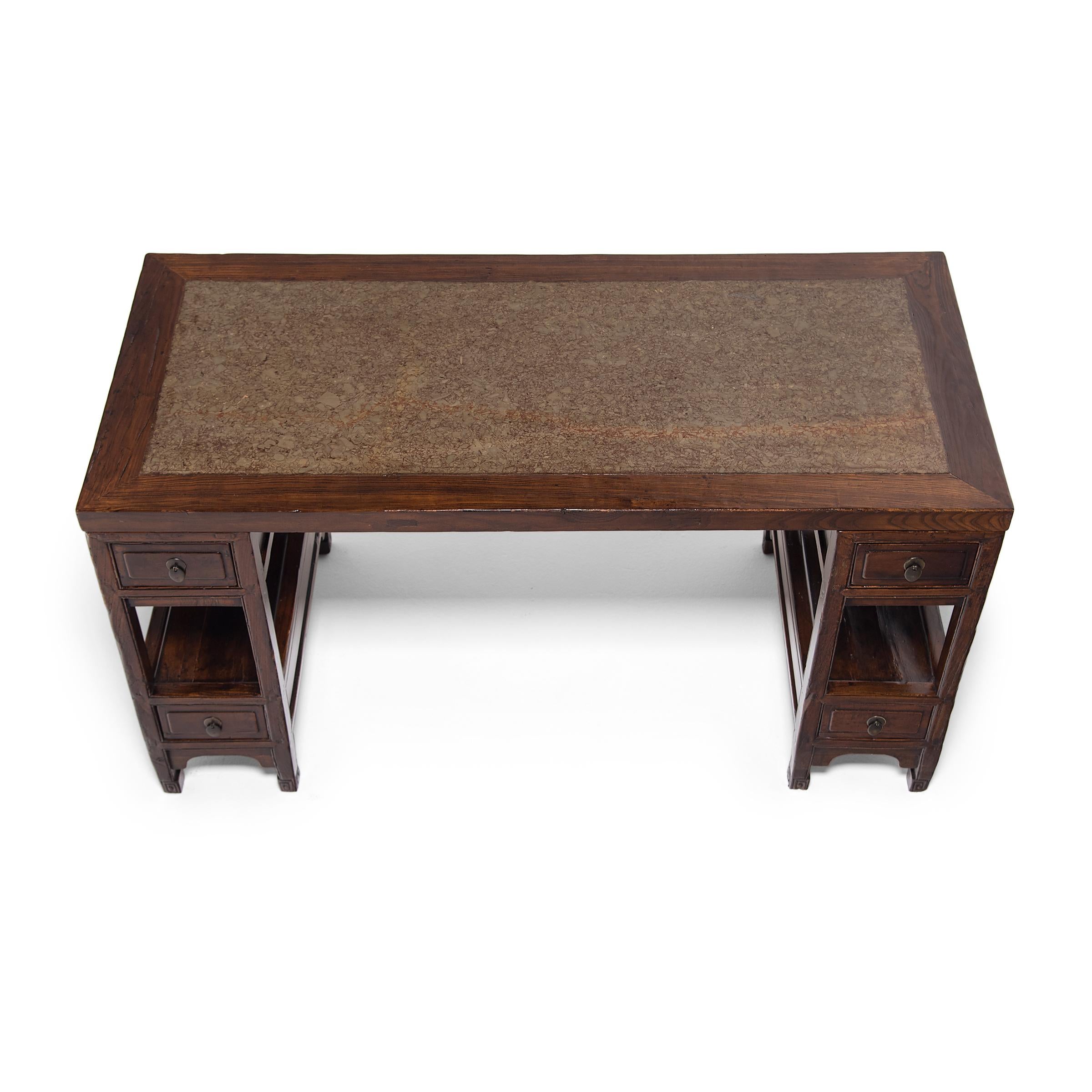 Finely crafted of lacquered elmwood, this stone top writing desk once stood centerpiece in the luxurious office of a well-to-do professional of the late Qing-dynasty. Known as a partner's desk or doctor's desk, the elegant writing table is a