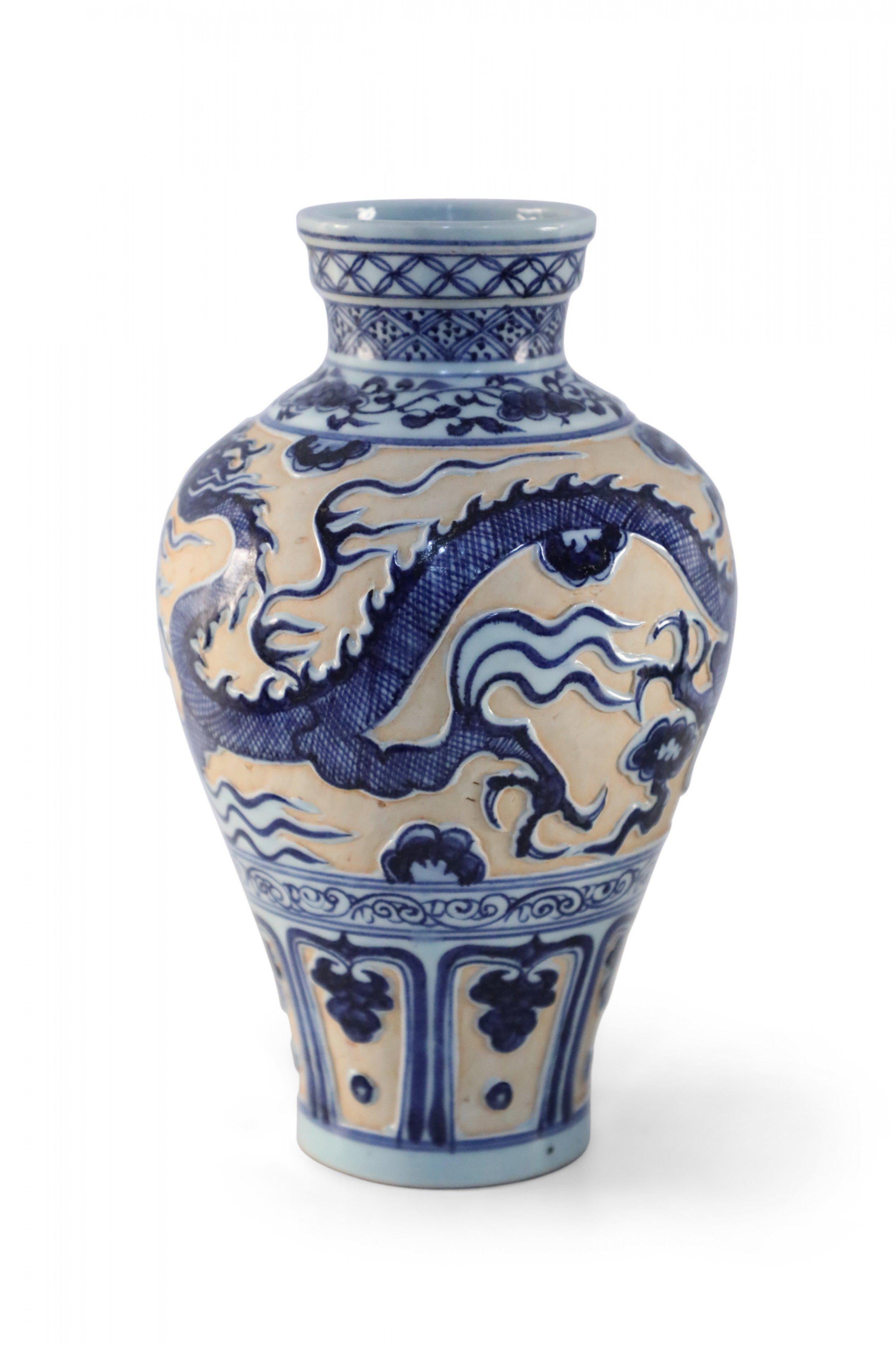 Vaso in porcellana cinese realizzato nello stile della dinastia Yuan che raffigura un drago blu e bianco in rilievo e smaltato su un fondo opaco color pesca e decorato con bande a motivi geometrici intorno all'apertura.

Condit: Buono; Usura