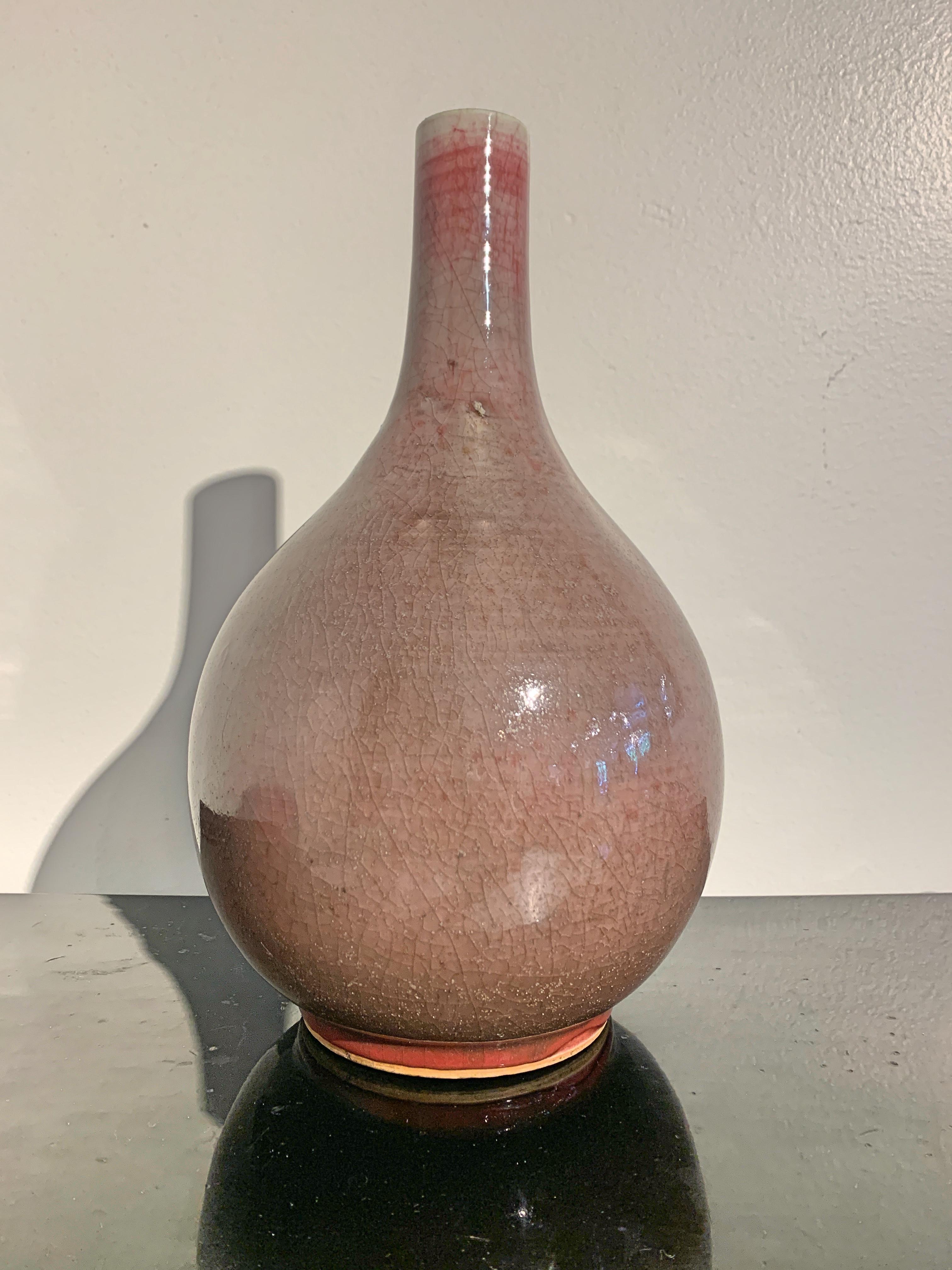A rare and demure Chinese peachbloom glazed porcelain bottle vase, Qing dynasty, 19th century, China.

The bottle vase of voluptuous form and elegant proportions, with a generous body of globular form and a narrow stick neck, all resting on a