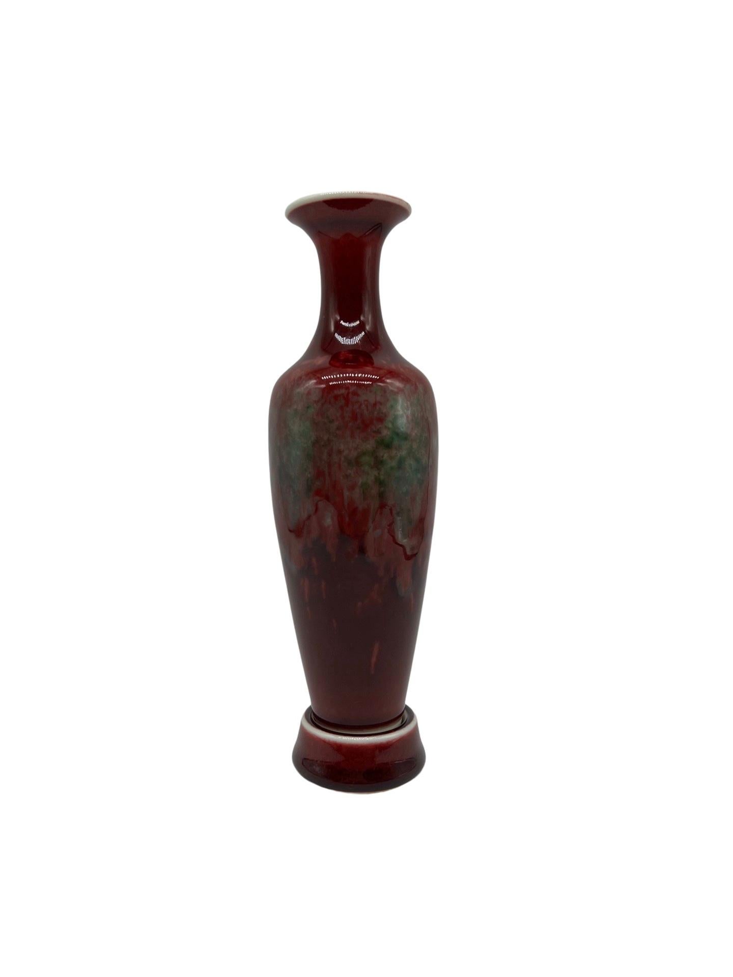 Chinese. A porcelain peachbloom oxblood porcelain vase with fitted base. 
Kangxi type mark to underside. 
Approx: 8.25