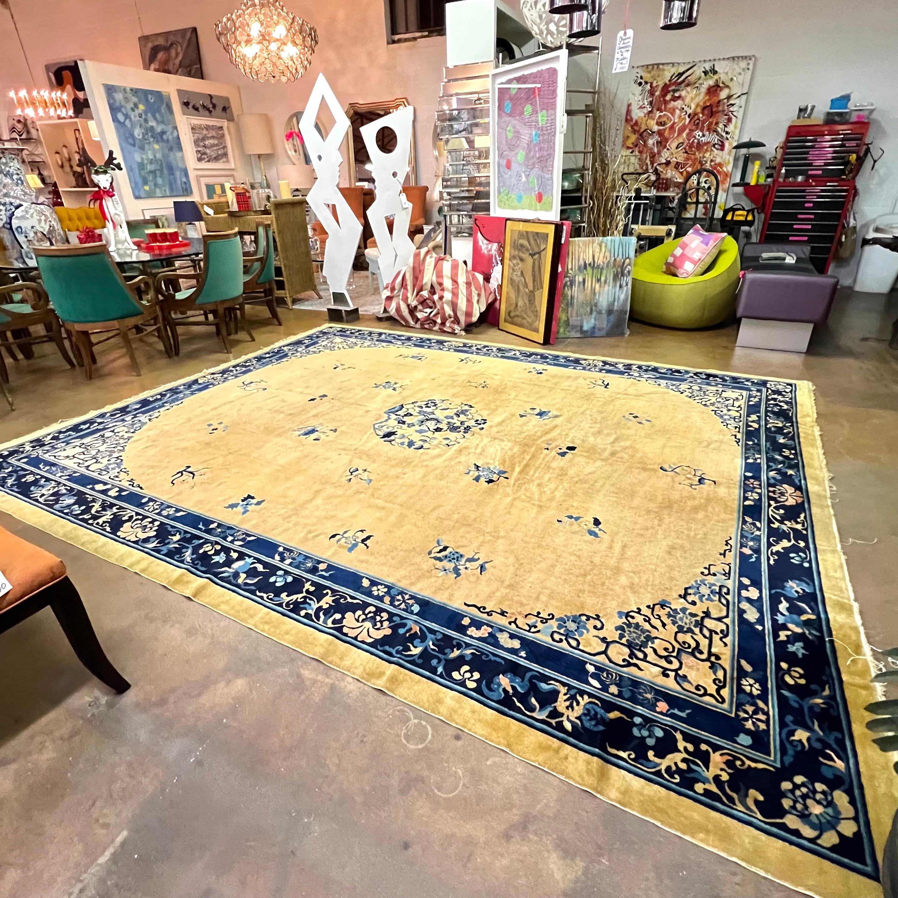 Amazing early 20th century Chinese Peking rug with a central floral medallion amidst a field of additional flowers on a beautiful gold field, surrounded by a deep blue border. Good antique condition; would benefit from professional cleaning.
10'W x