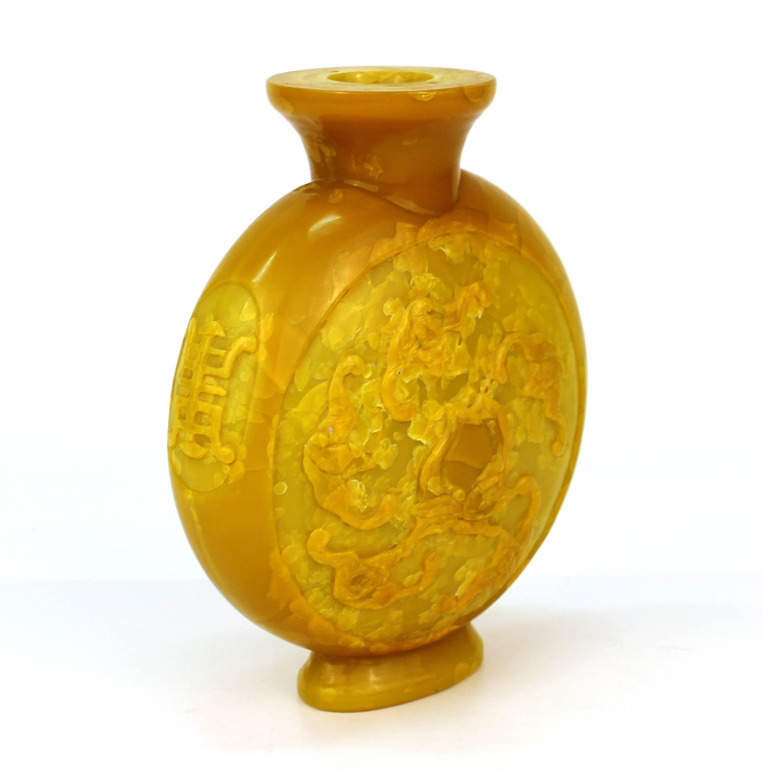 Chinesische Vase in Form eines Mondkolbens aus gelbem Glas mit Hochreliefmotiv aus Fledermäusen und Pfirsichen auf einem Hintergrund mit Craquelé-Muster. Das Stück stammt aus dem 19. Jahrhundert und trägt darunter eine apokryphe Qianlong-Marke. In