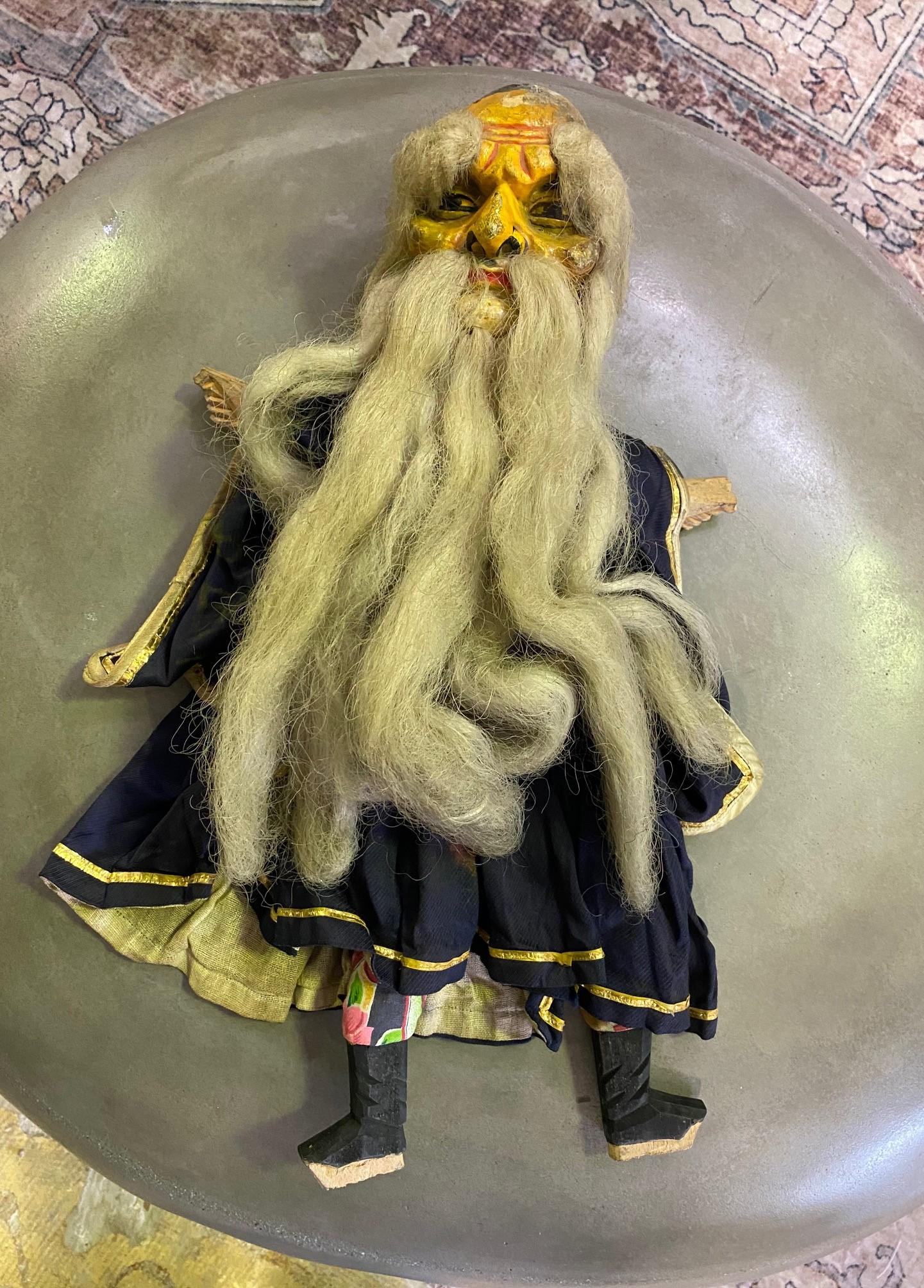 A wonderful work complete with a unique wood-carved and hand-painted face, long grey beard, and original textile garment. 

From a group of 7 Chinese opera puppets, we acquired from a collector. Each puppet shows clear signs of previous stage use.