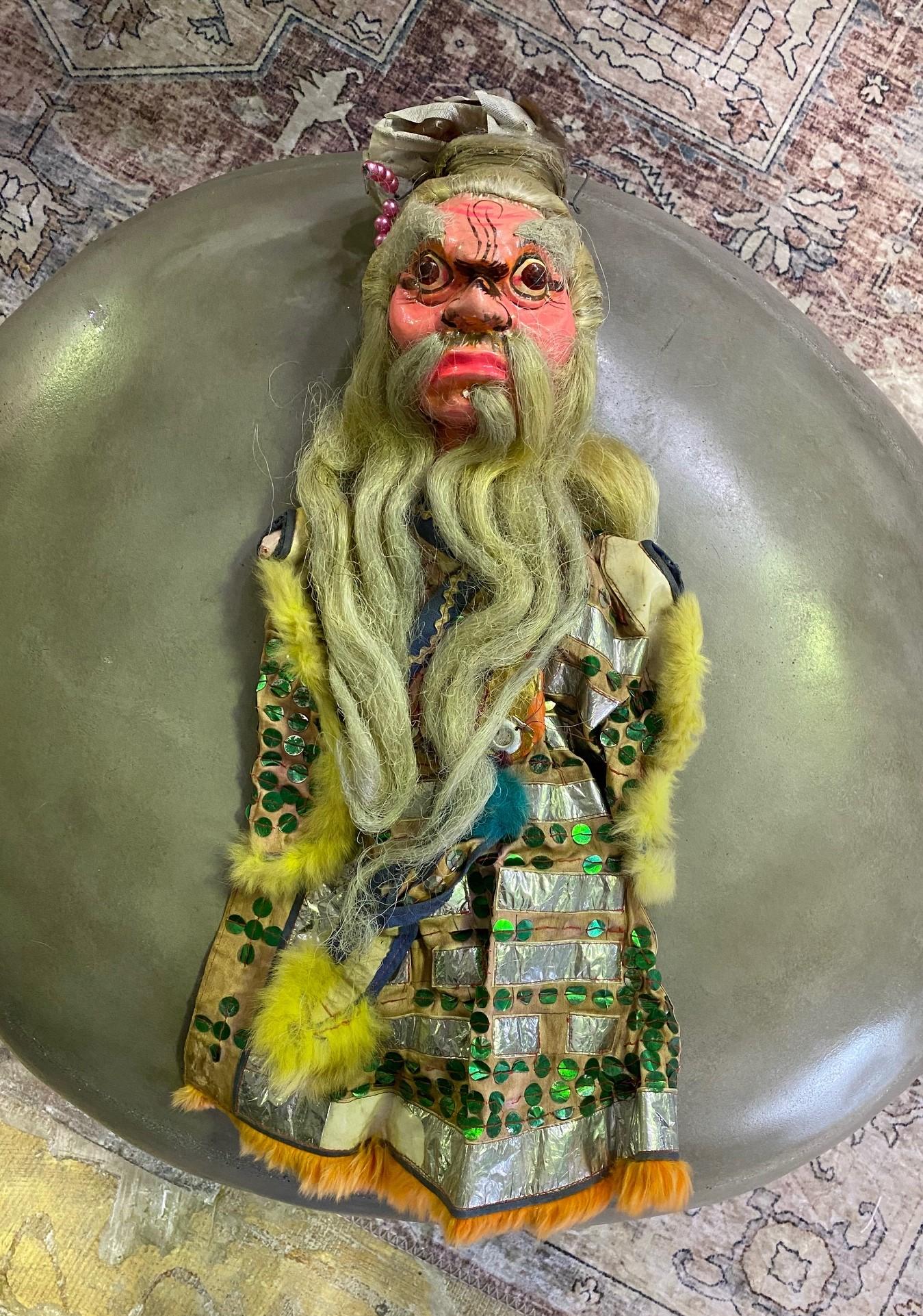 A wonderful work complete with a unique wood-carved and hand painted face and original textile garment. 

From a group of 7 Chinese opera puppets, we acquired from a collector. Each puppet shows clear signs of previous stage use.

Likely from