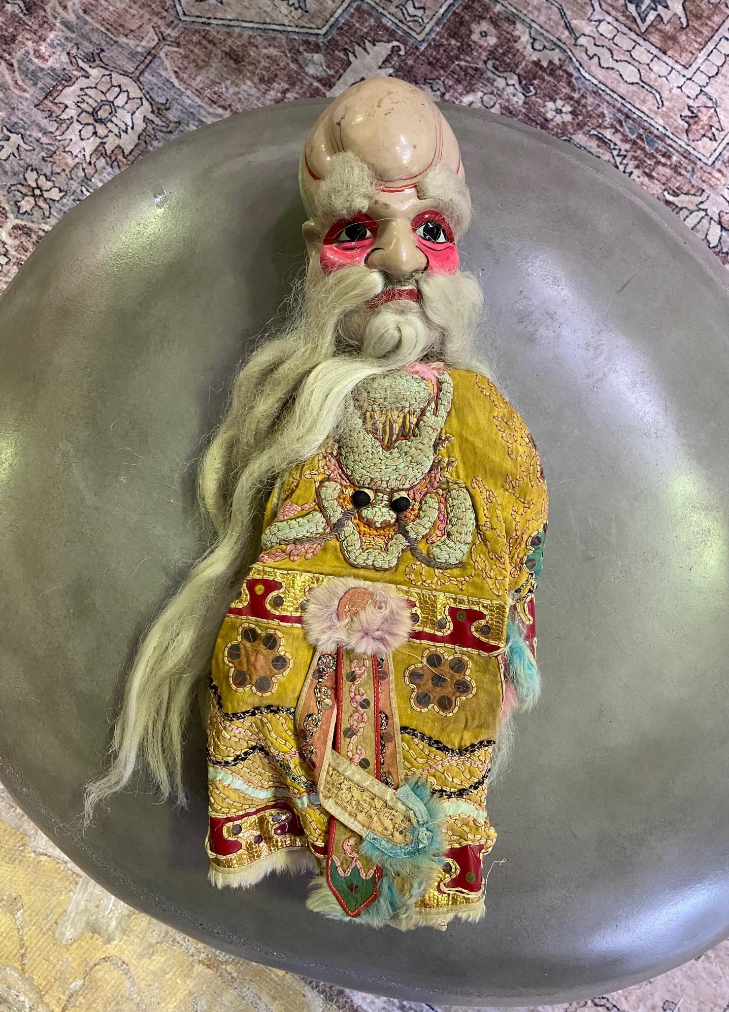 A wonderful work complete with a unique wood-carved and hand-painted face and original textile garment/ robe with a dragon symbol. 

From a group of 7 Chinese opera puppets, we acquired from a collector. Each puppet shows clear signs of previous