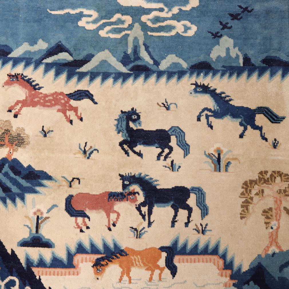 Chinese Peking Pictorial Rug, a square carpet hand-knotted wool pile on a cotton foundation depicting six multi-coloured wild horses in a beige field having trees, pond, grasses, mountains in the distance, clouds, birds and rocky foreground corners