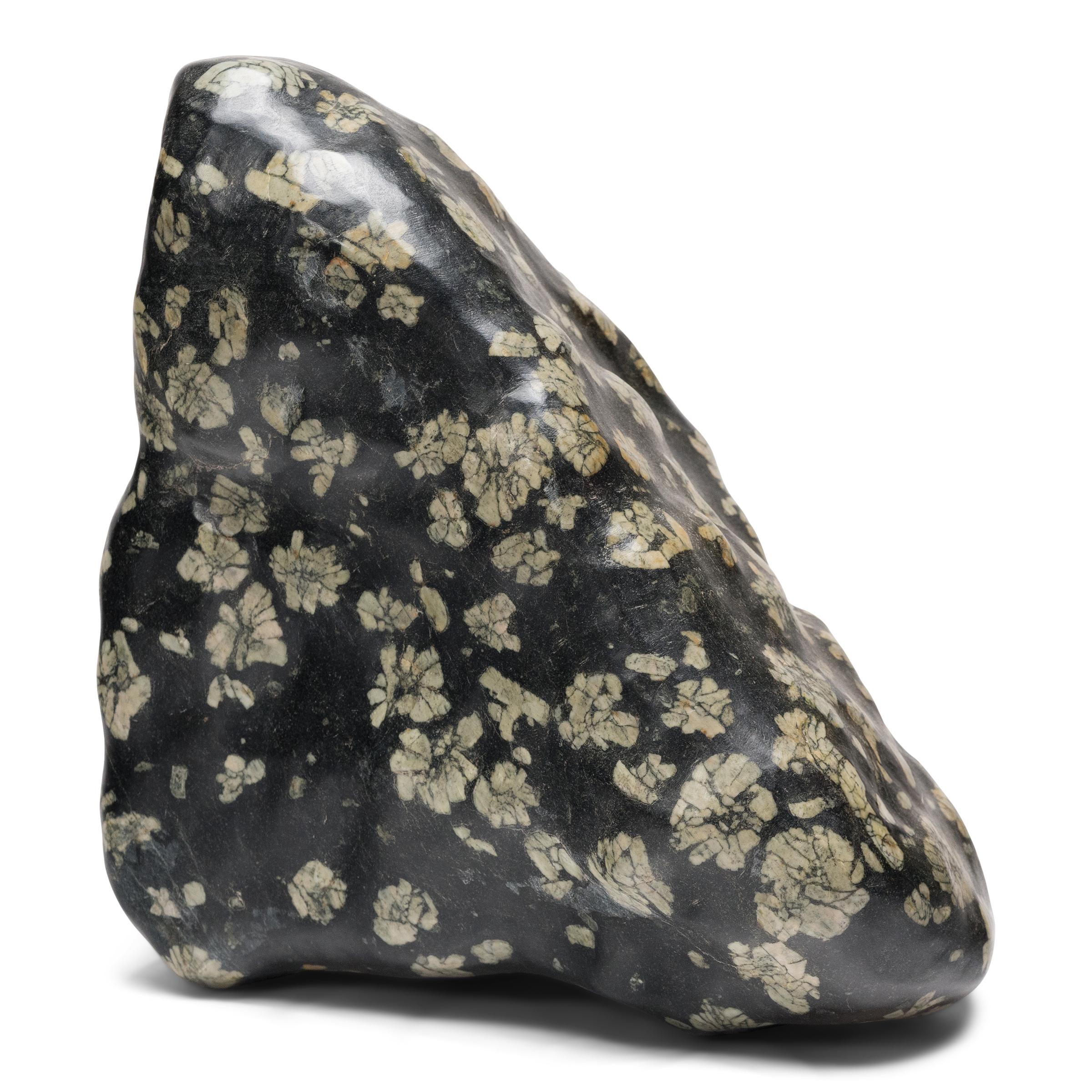 Sourced from Henan province, this sculptural meditation stone looks as if it were sprinkled with a flurry of peony blossoms, the result of flower-like aggregates of lighter-colored feldspar incorporated into the stone’s dark, fine-grained ground.