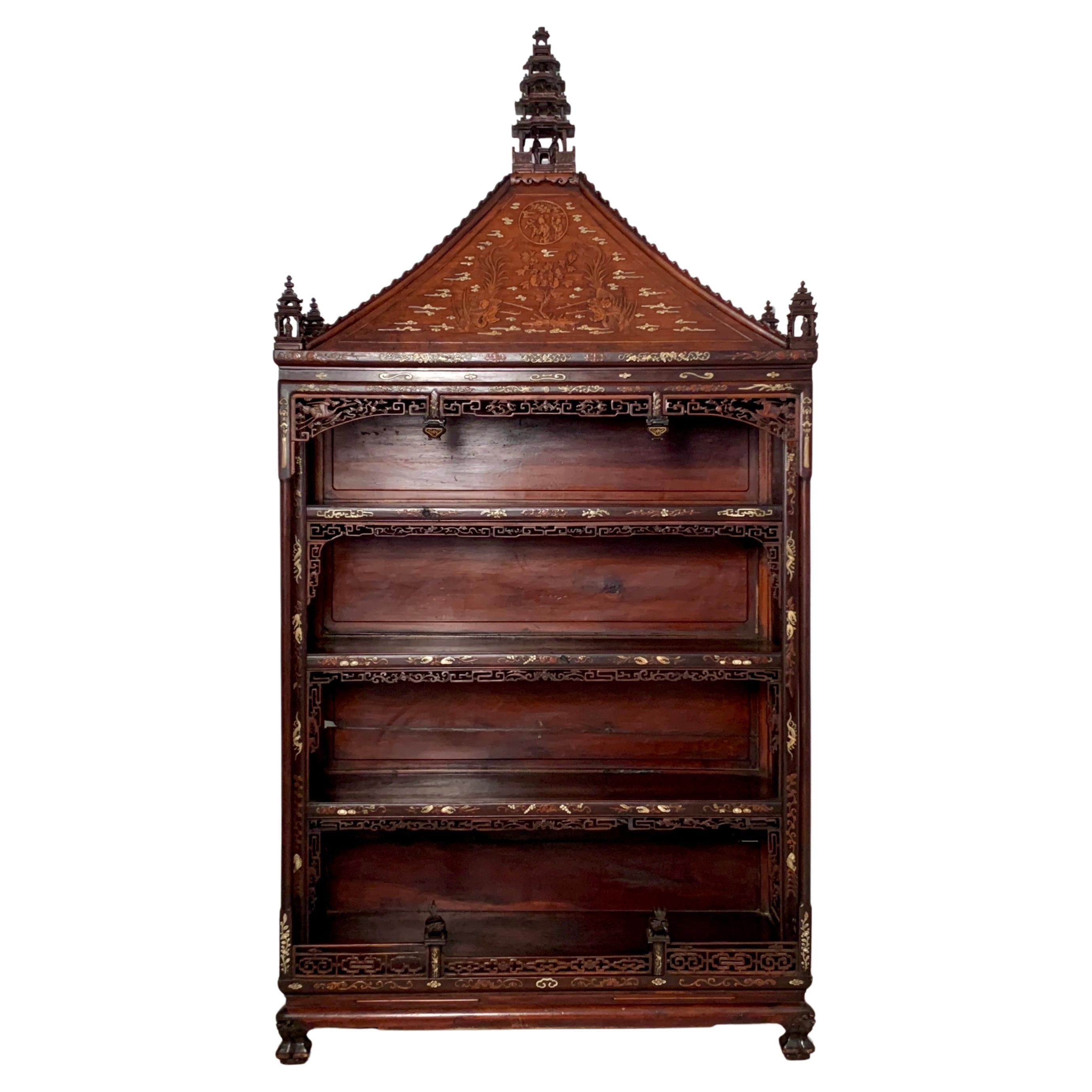 An impressive pagoda form carved hardwood display cabinet with bone and boxwood inlay, crafted for the Peranakan (Straits-Chinese) community in Southeast Asia, mostly likely Malaysia, Indonesia, or Singapore, early 20th century.

The large display