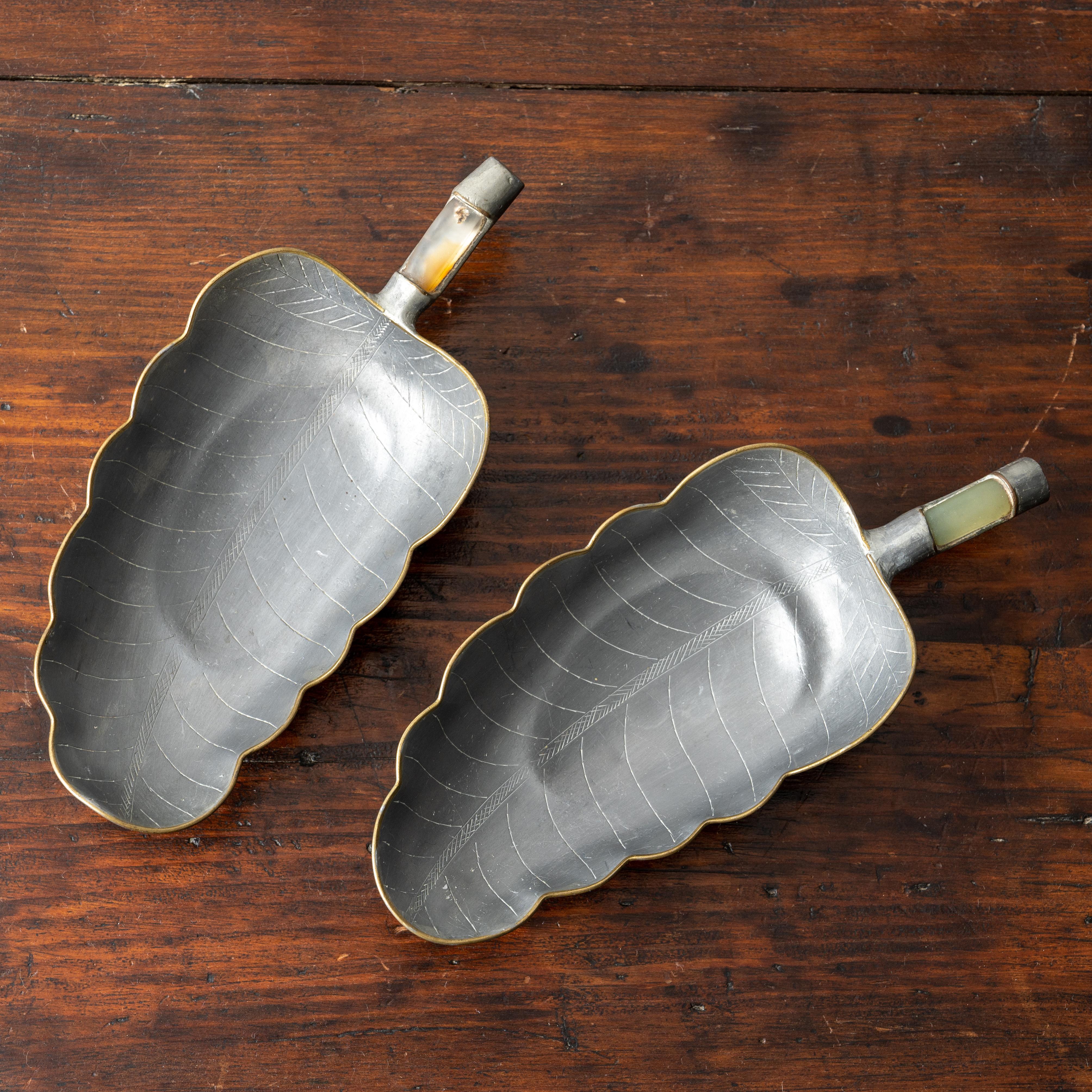 A pair of Chinese pewter and jade banana leaf dishes, circa 1910s.

6 ½ inches wide by 3 inches deep by 1 ¼ inches tall



