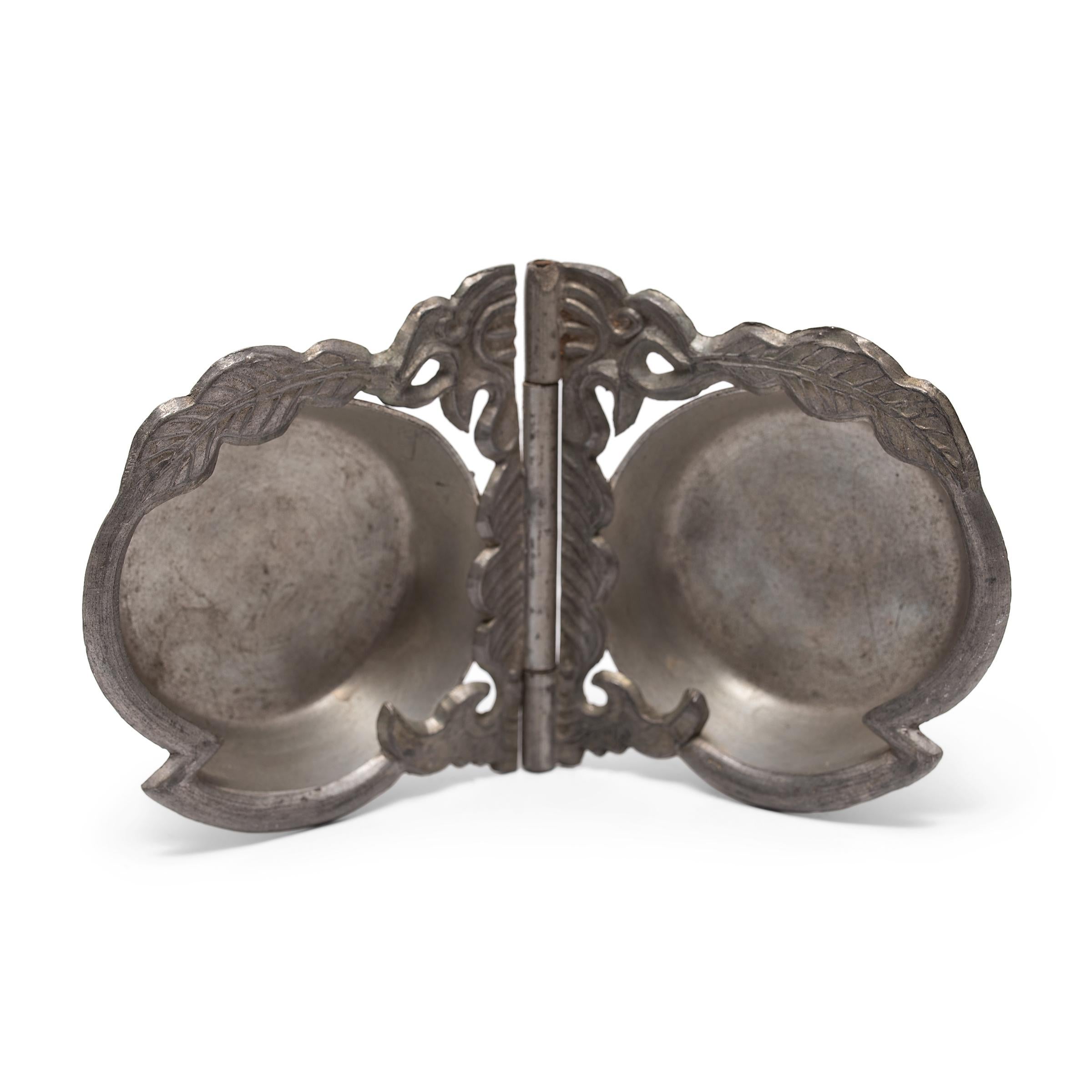 This hand held pewter dish is an excellent example of fine Chinese metalwork of the 20th century. During the Qing dynasty, pewter craftsmen experimented with new techniques, showing the influence of Western silver tableware styles as well as Manchu