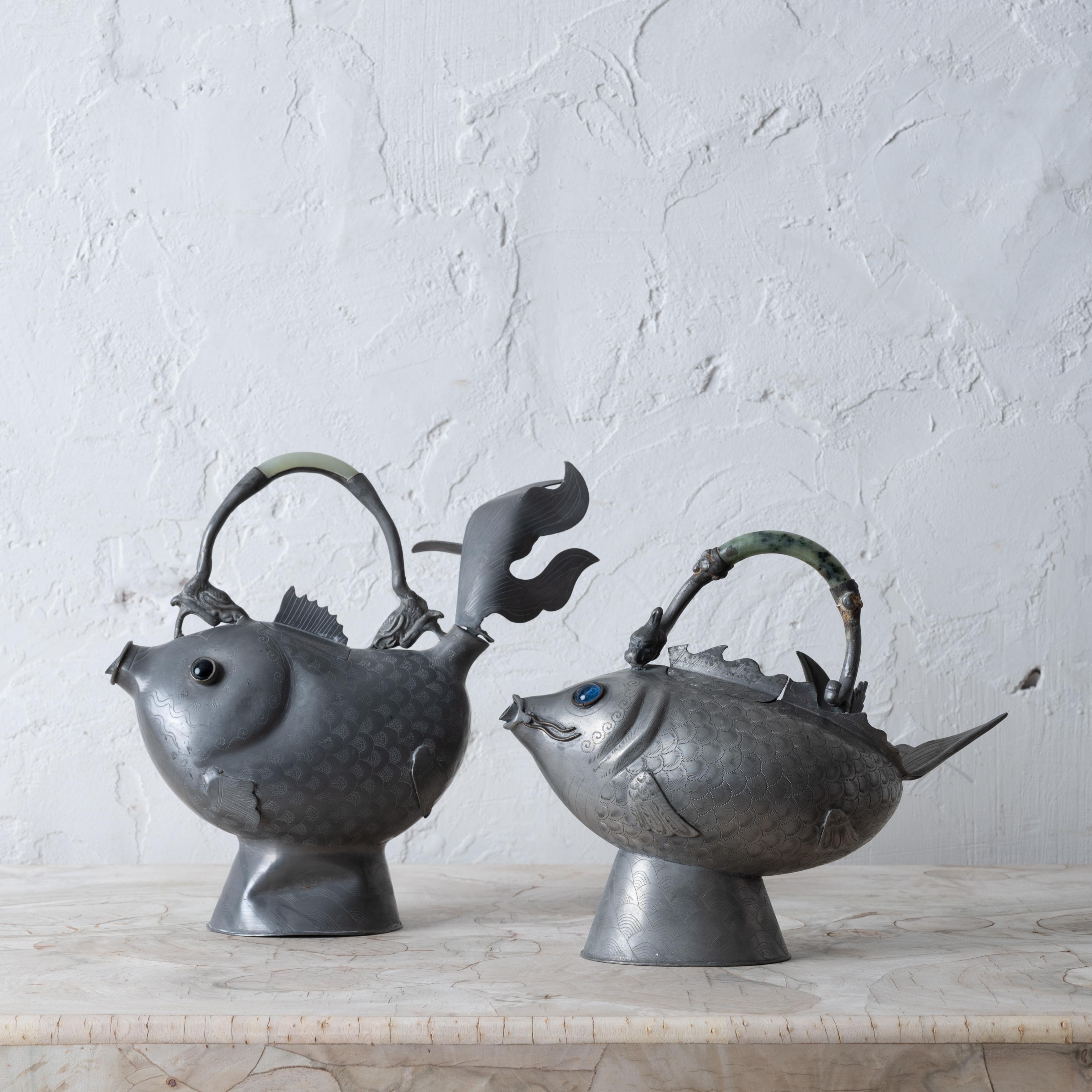 A pair of Chinese pewter koi-form teapots, 19th Century.

larger: 9 ¾ inches wide by 4 inches deep by 9 ¼ inches tall

smaller: 9 ½ inches wide by 4 ½ inches deep by 7 ¾ inches tall


