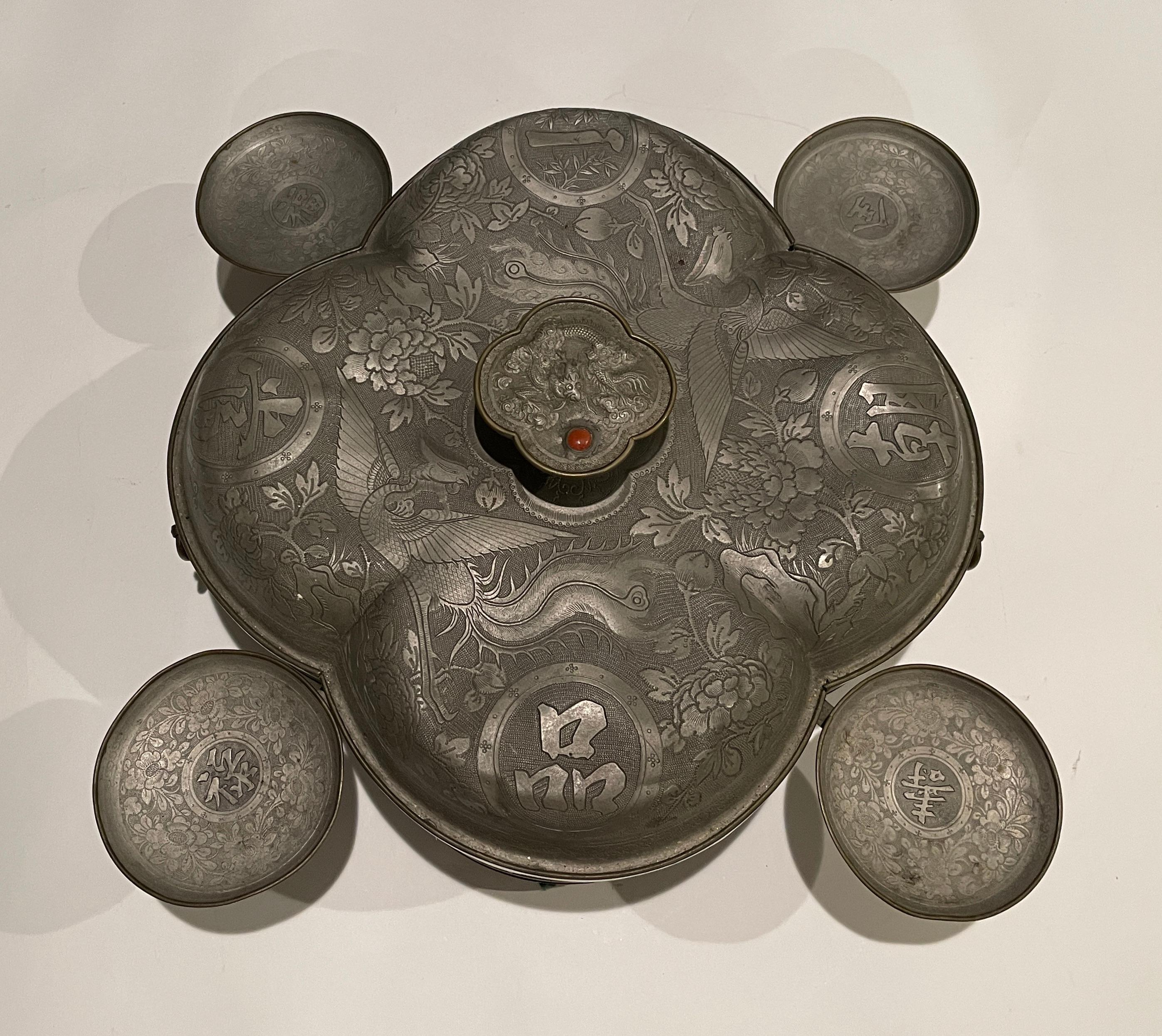 Chinese Pewter lobed hot water dish/supper set, chased Dragon and Vermilion or Fenghuang bird with lotus blossoms and scrollwork and decorated with brass trim, the cover cabochon mounted and concealing four covered compartments with similar mounts