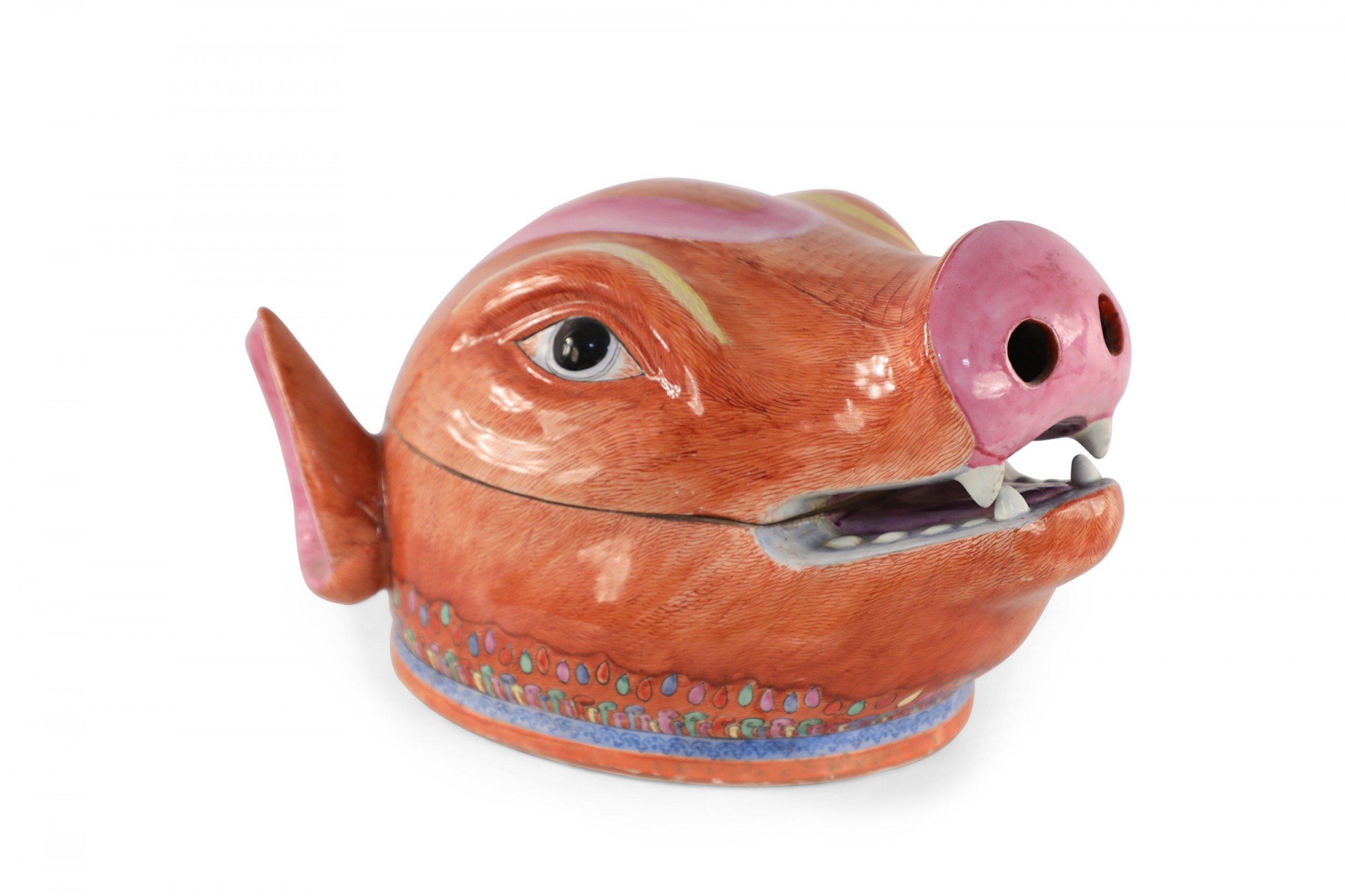 Soupière ancienne en porcelaine d'exportation chinoise (début du 20e siècle) en forme de tête de cochon orange et rose divisée en couvercle et base au niveau de l'embouchure, et décorée d'un motif coloré autour de la base.
 