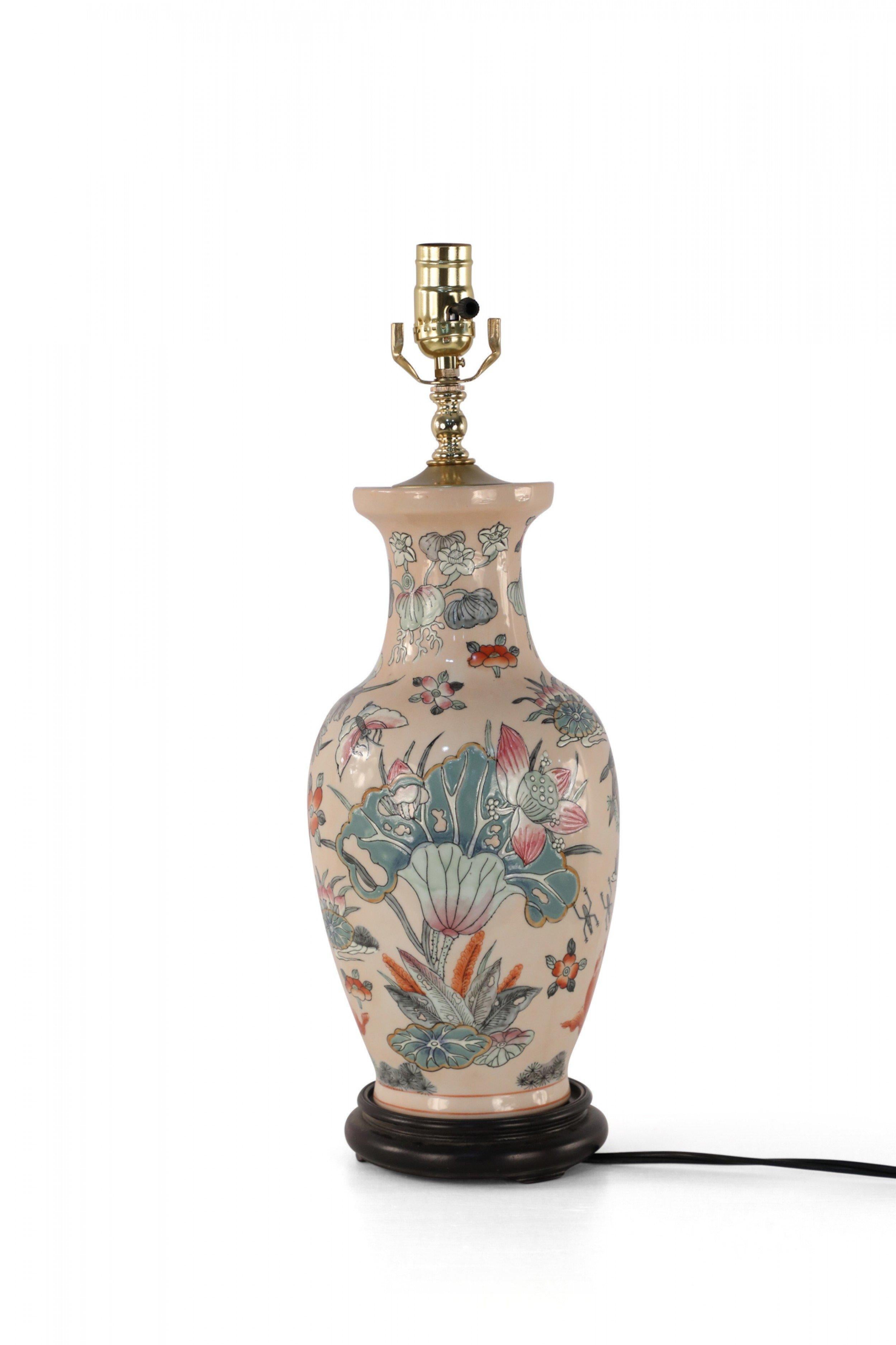 Chinese pink ceramic table lamp made from a baluster-shaped vase decorated with colorful birds, florals and koi on a wooden base with brass hardware.
     