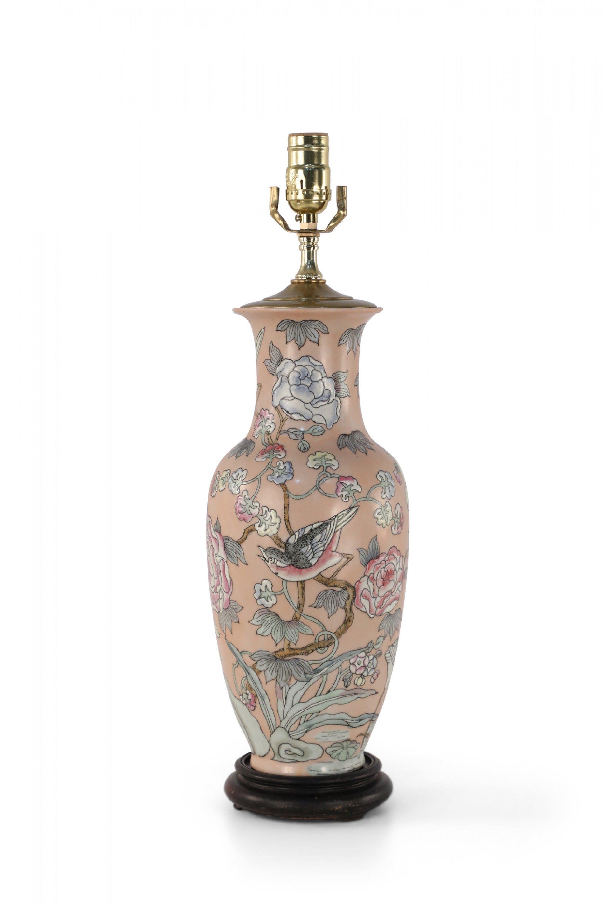 Chinese pink porcelain table lamp made from a baluster-shaped vase decorated with cranes and sparrows in natural surroundings emphasized with linework and lightly colored florals, on a wooden base with brass hardware.
       