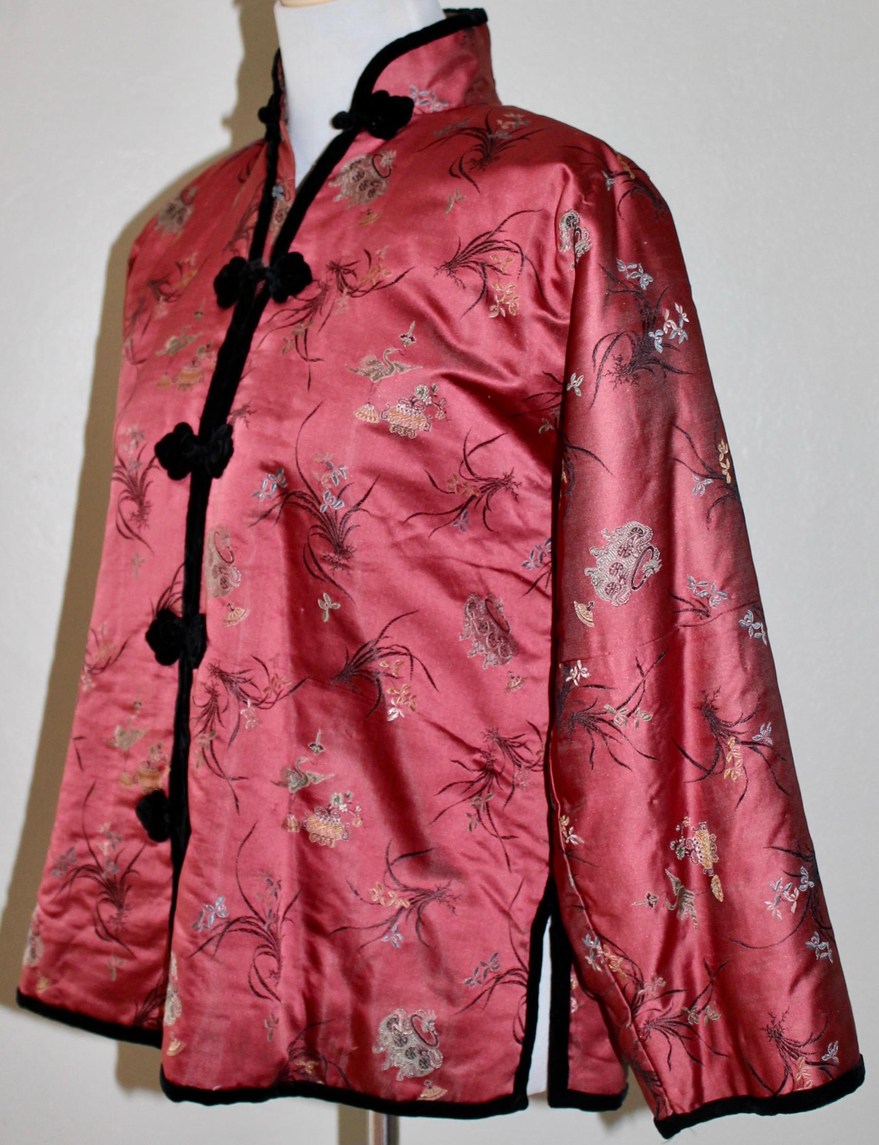De forma típica, grandes lampas de seda rosa rojiza,  con motivos florales chinos y cisnes voladores, tejidos en la tela. Ganchos y ribetes de terciopelo negro De hombro a hombro 16