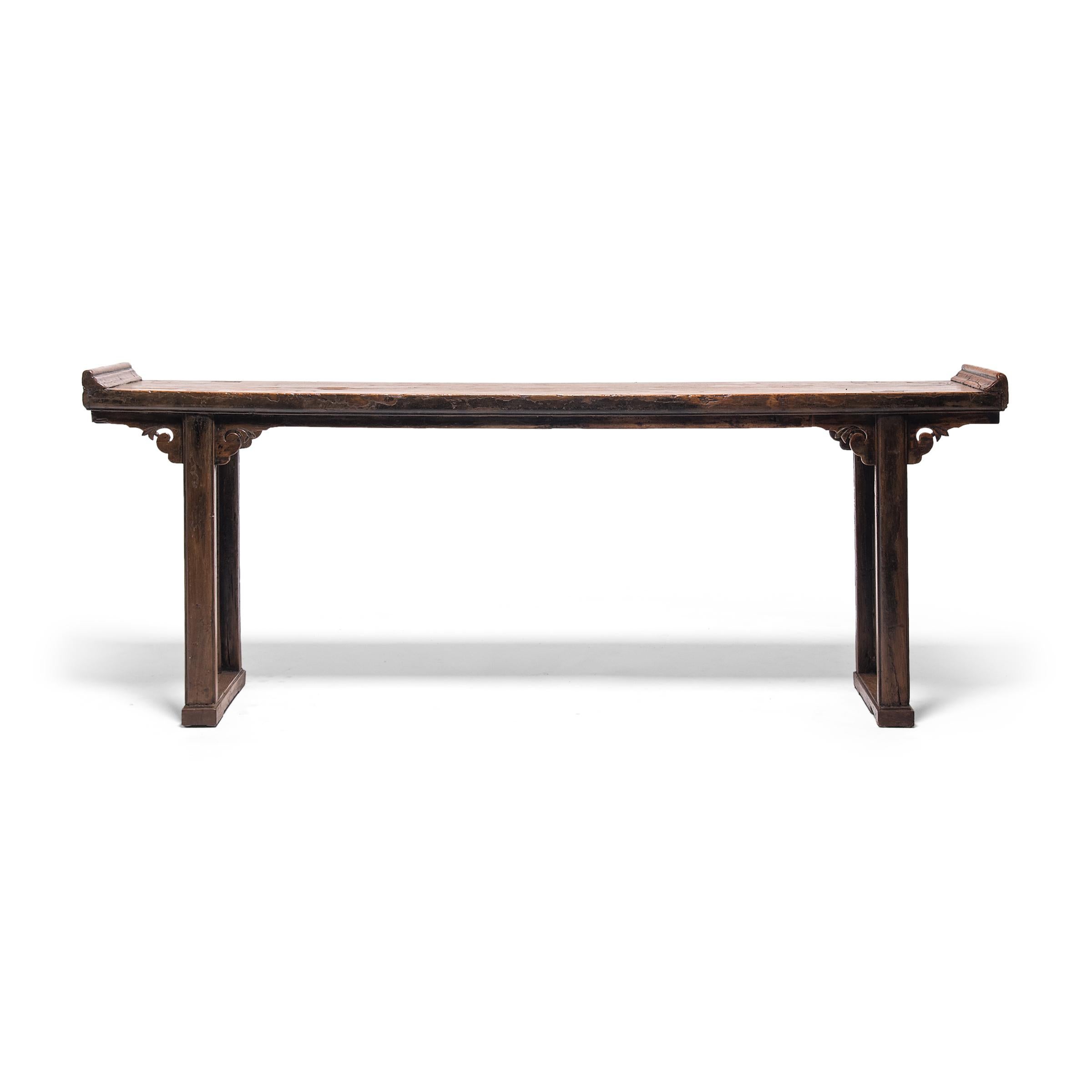 With everted ends and straight square legs, this 19th century altar table embodies Classic Qing dynasty design. Originally used as a domestic altar for ancestor worship, the long console has an expansive tabletop surface and is minimally decorated