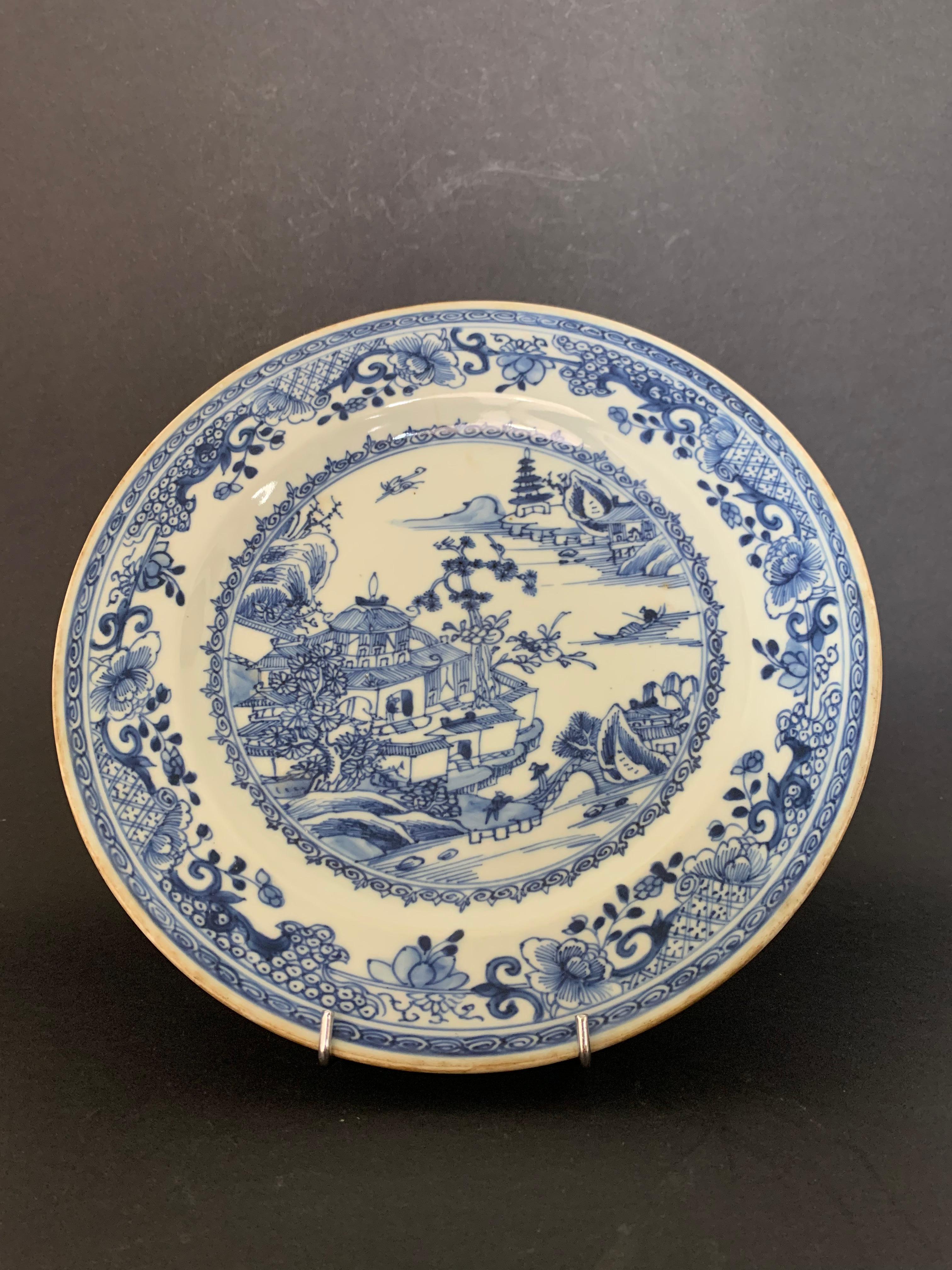 Nice plate inspired the Compagnie des Indes from the Qianlong period, XVIIIth century, But dating from the 19th Century. 
It presents a decoration of pagoda, lake landscape and flowering trees. This porcelain is characteristic of the blue family.