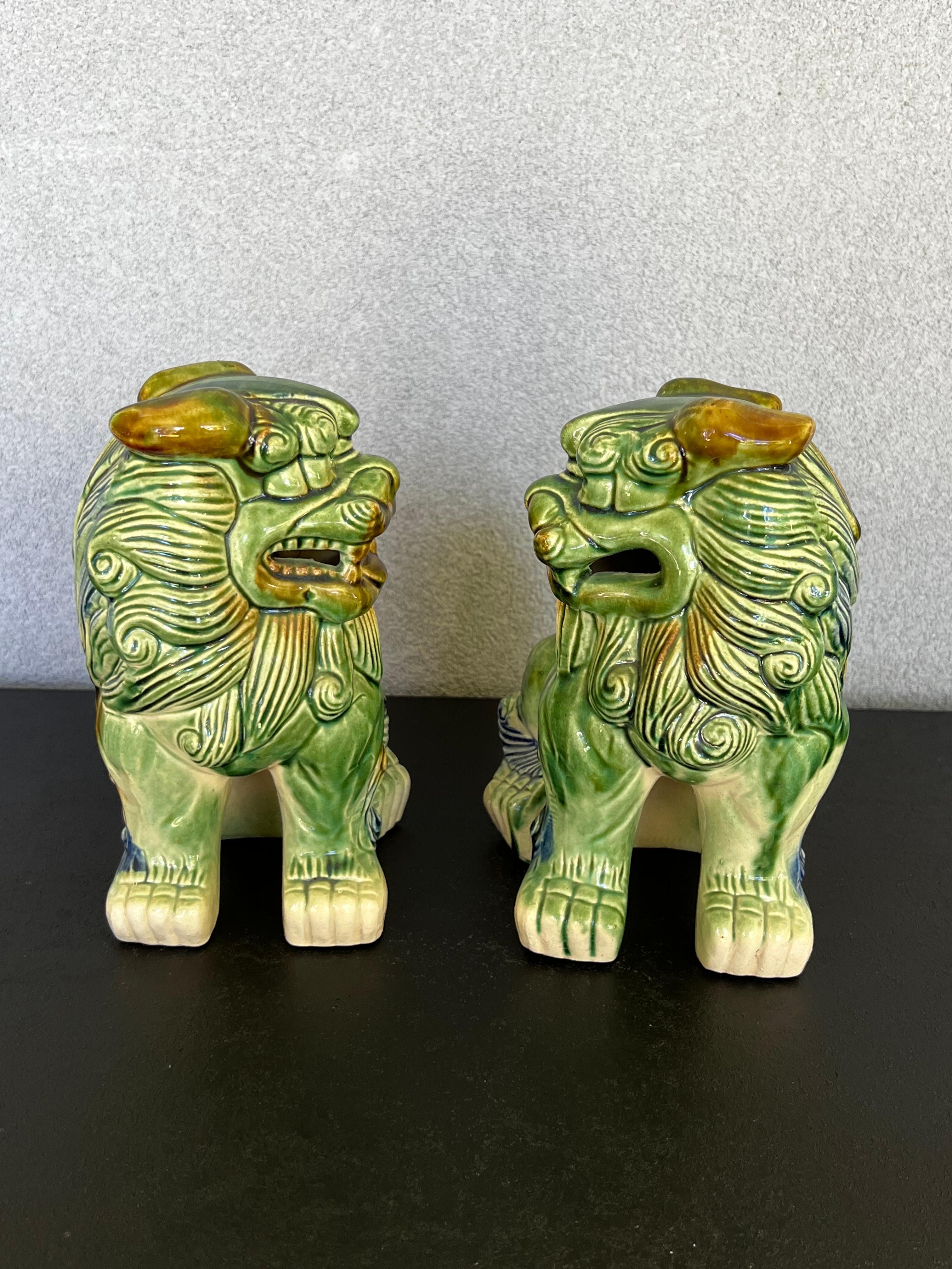 Vintage Pair of Ceramic Glaze Polychrome Chinese foo dog sculptures. Features a color palette of cream, green blue and brown.
this pair has a nice size that could be use on a fireplace mantle or entry table. Colors are rich and vibrant 