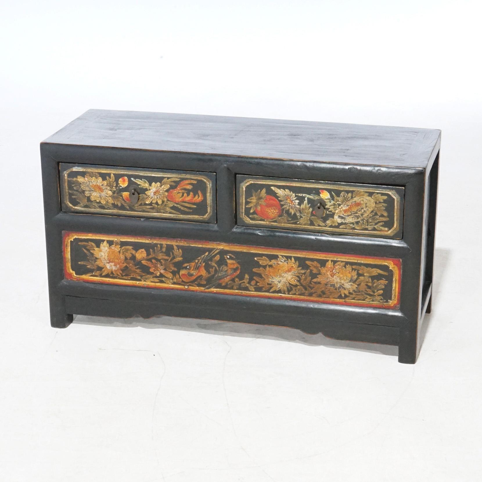 A Chinese polychrome low chest offers two smaller upper drawers and a single lower long drawer, each with hand-painted garden elements including birds, foliate, floral and fruit elements, 20th century

Measures - 16.5