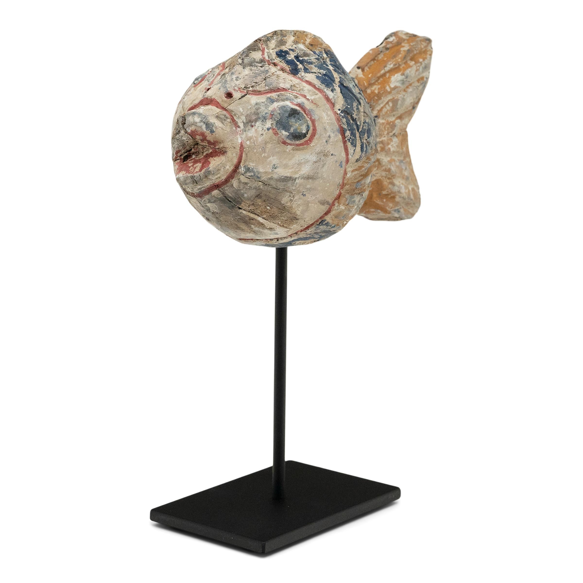 Hand-crafted from reclaimed wood, this artist-made koi is a traditional symbol of harmony and wealth. For Buddhists, such a fish represents a freedom from all restraints. The scales and fins on the squat, rounded body are highlighted with blue,