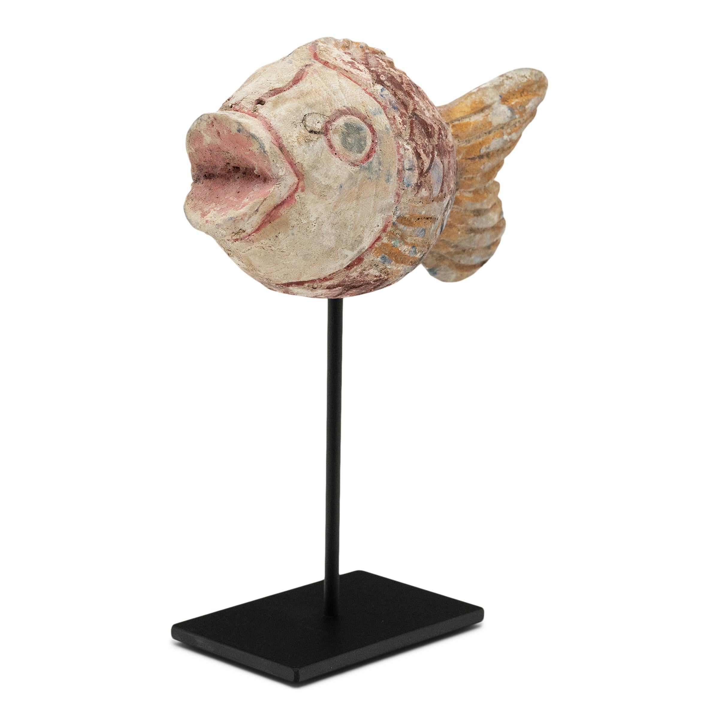 Hand-crafted from reclaimed wood, this artisanal koi sculpture is a traditional symbol of harmony and luck. For Buddhists, such a fish represents a freedom from all restraints. The fish is sculpted with a squat, rounded body and decorated with