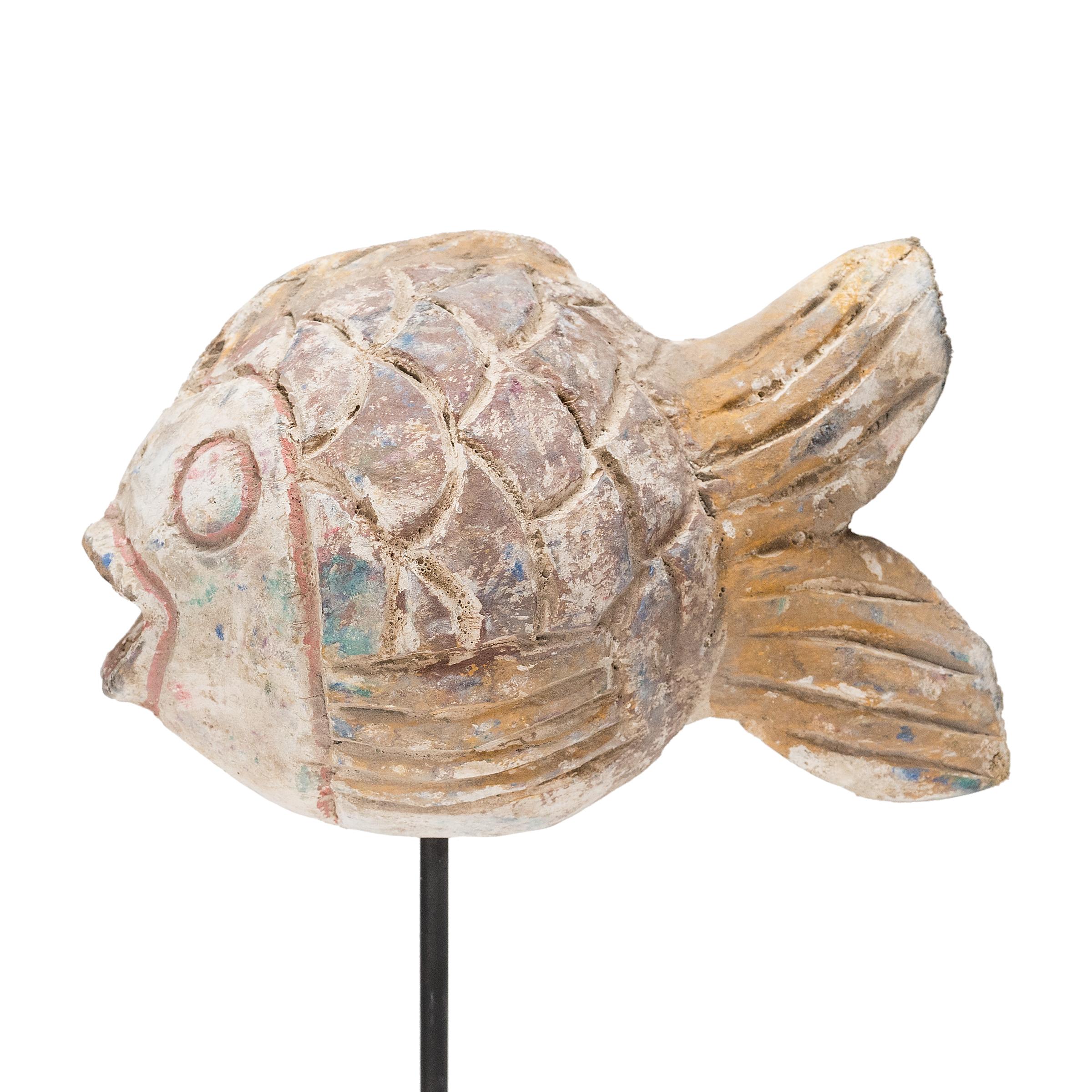 Hand-crafted from reclaimed wood, this artisanal koi sculpture is a traditional symbol of harmony and luck. For Buddhists, such a fish represents a freedom from all restraints. The fish is sculpted with a squat, rounded body and decorated with