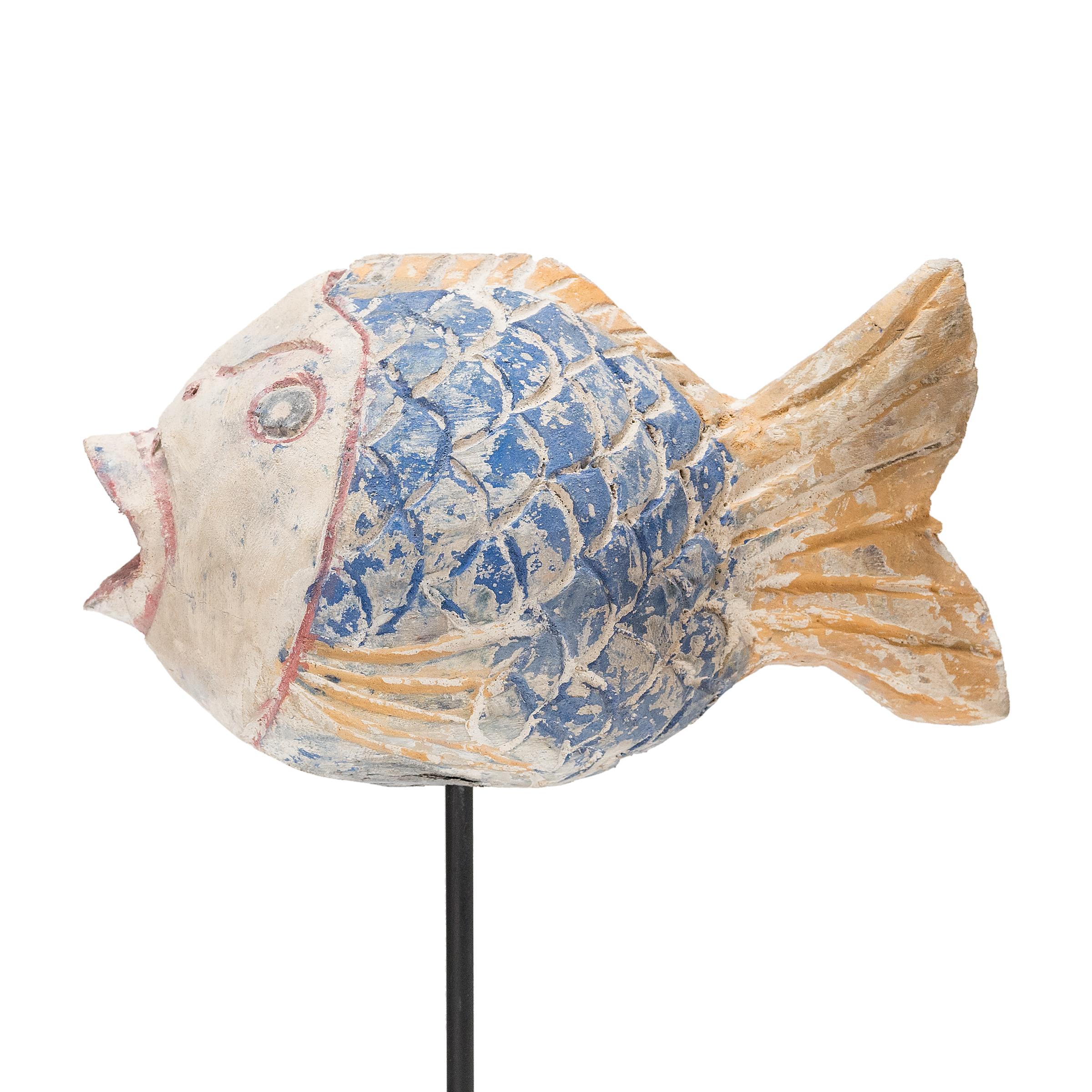 Hand-crafted from reclaimed wood, this artist-made koi is a traditional symbol of harmony and wealth. For Buddhists, such a fish represents a freedom from all restraints. The scales and fins on the squat, rounded body are highlighted with blue,